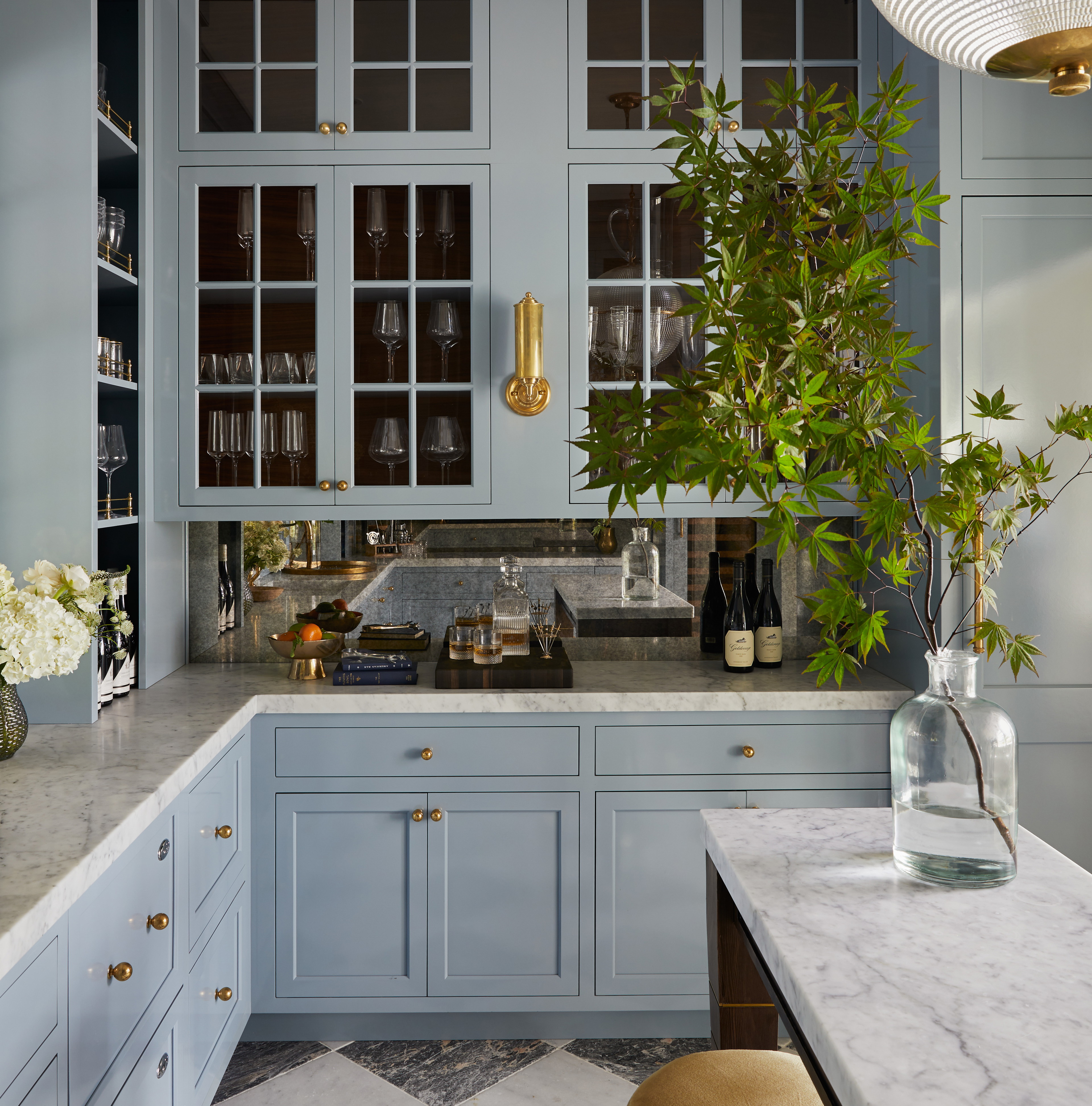 a kitchen with blue cabinets and marble counter tops