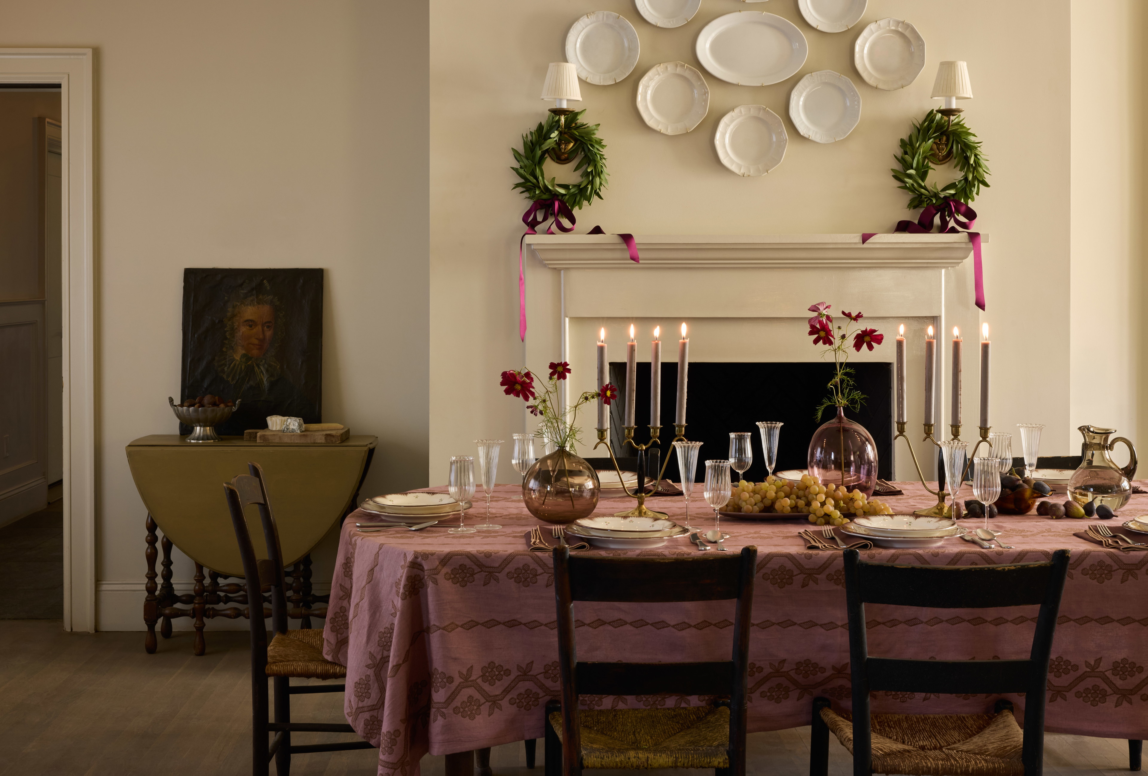 a dining room table set with plates and candles