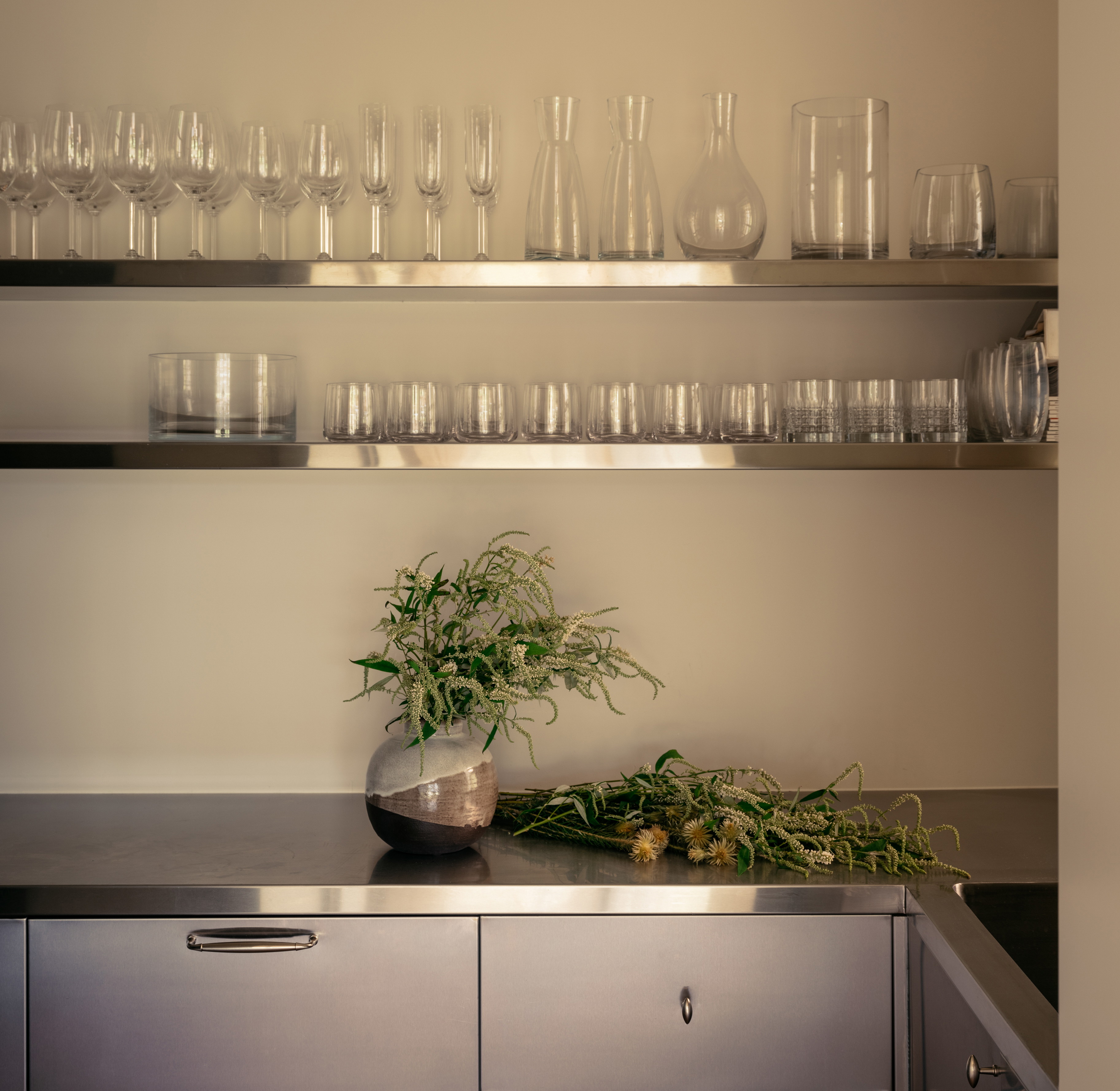 a kitchen counter topped with lots of glassware