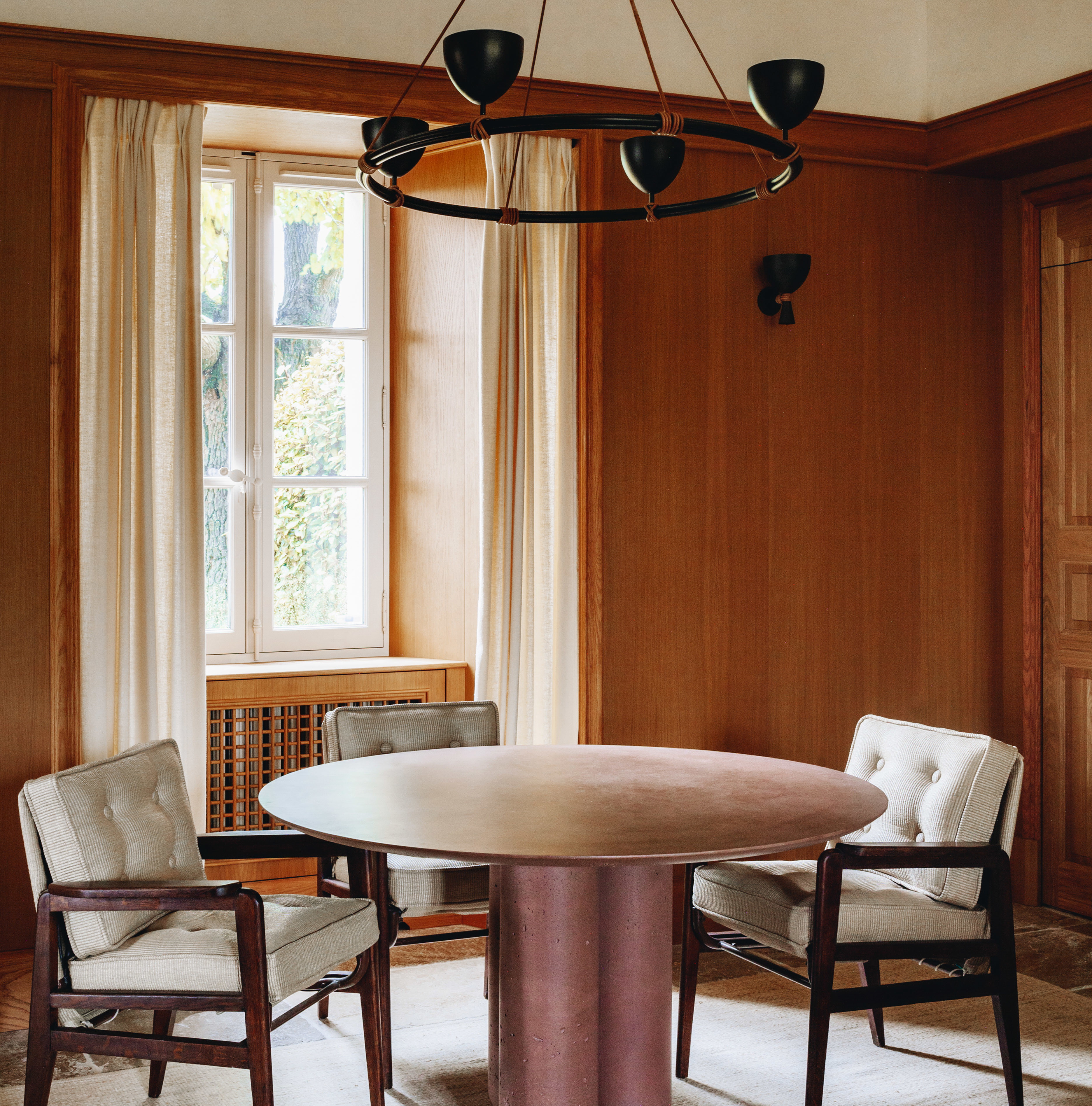 a dining room with a round table surrounded by chairs