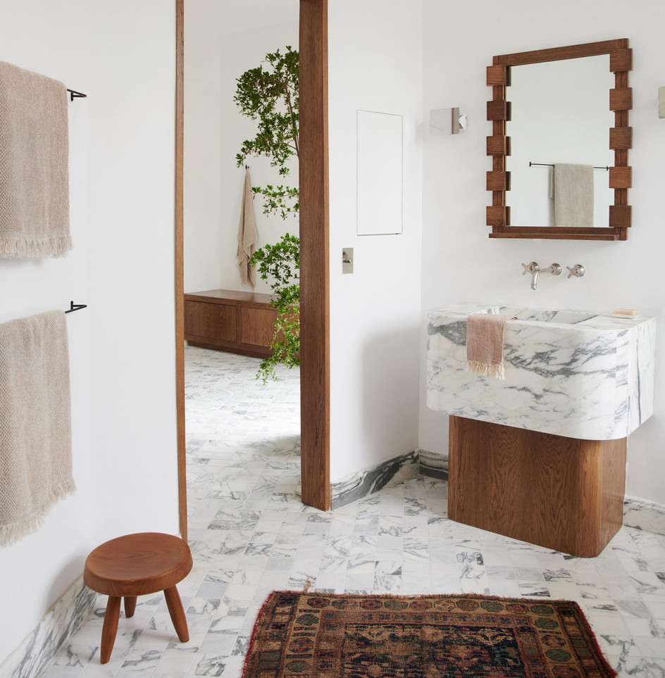 a bathroom with a marble counter top and a mirror