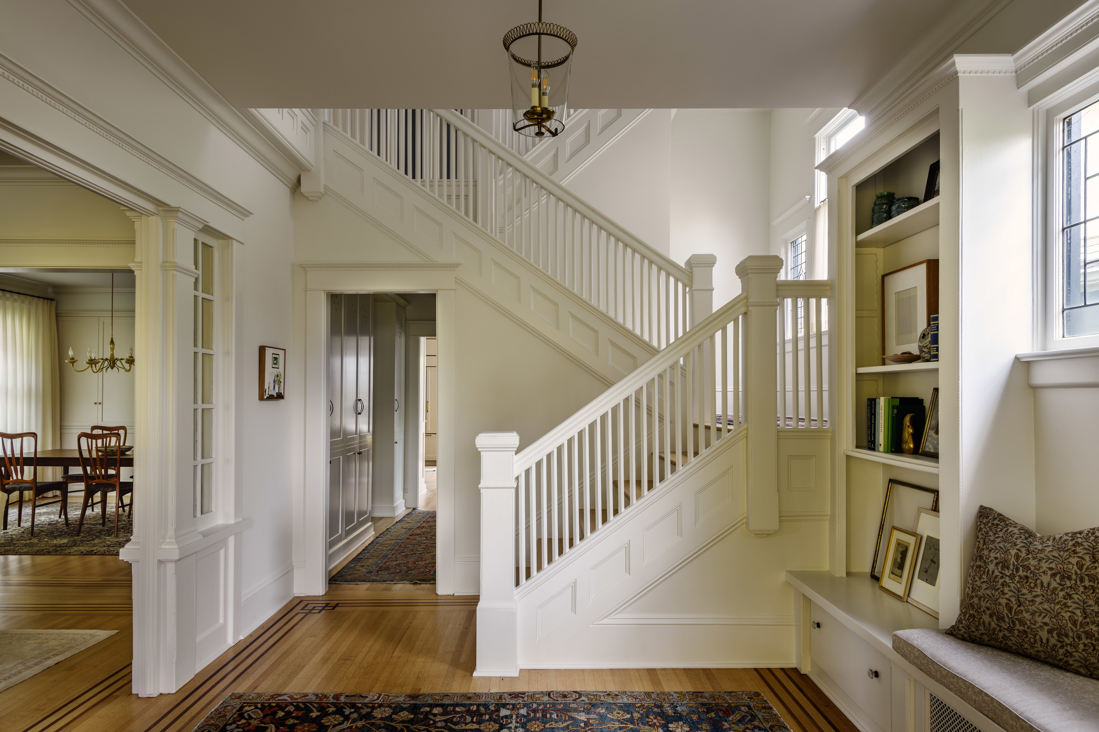 a hallway with a bench and a staircase