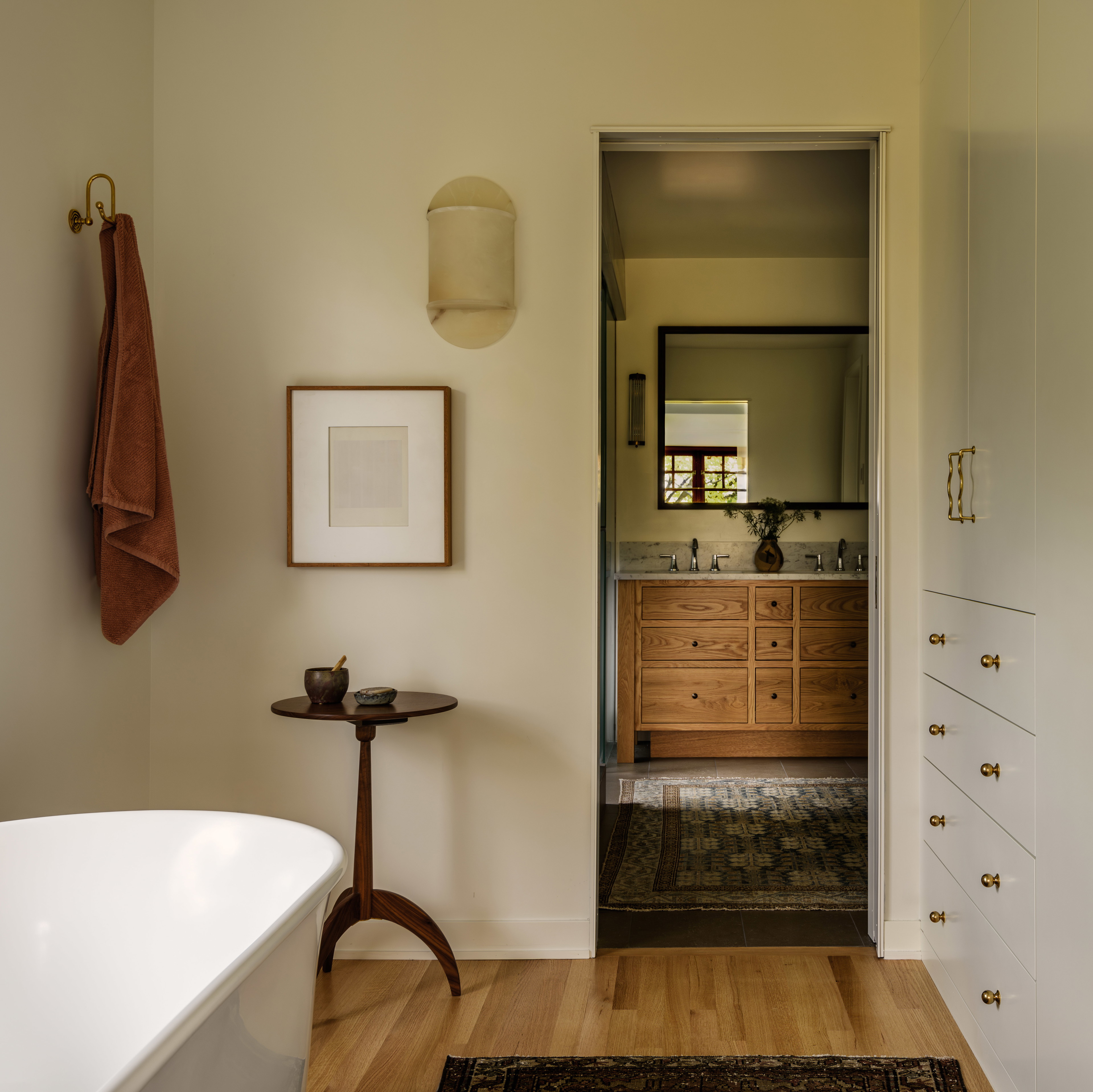 a bathroom with a white bath tub sitting next to a wooden floor