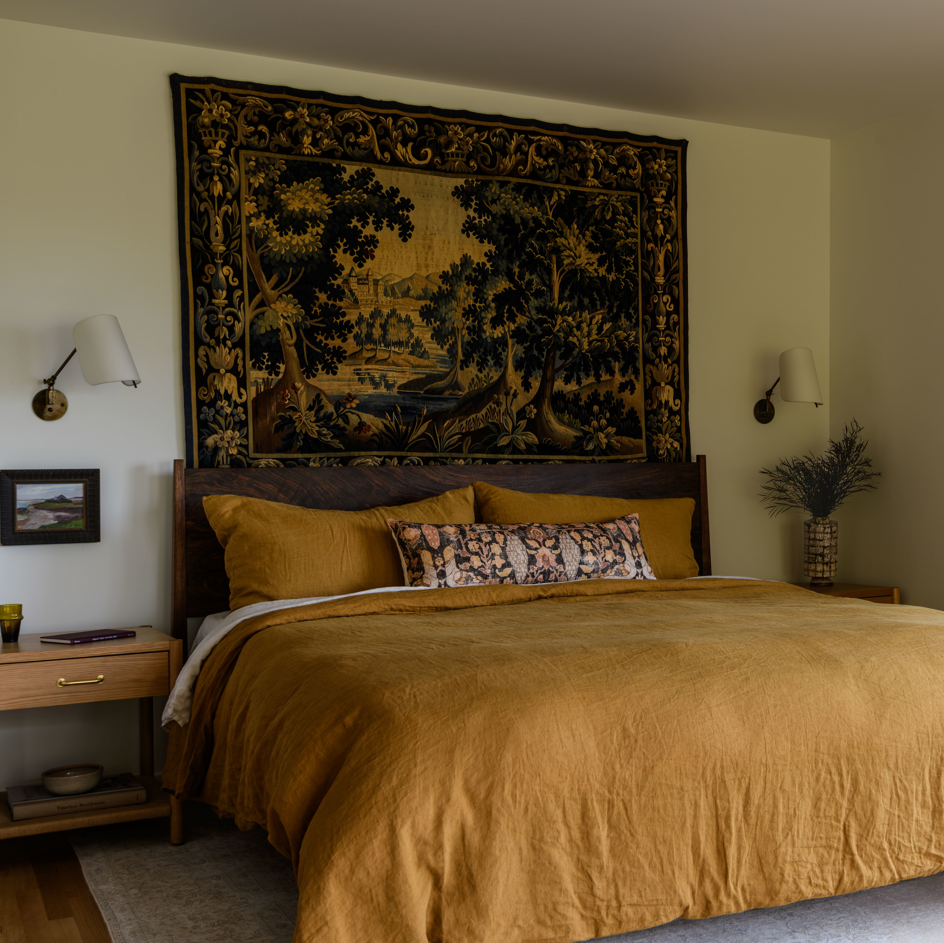 a bedroom with a large tapestry hanging above the bed