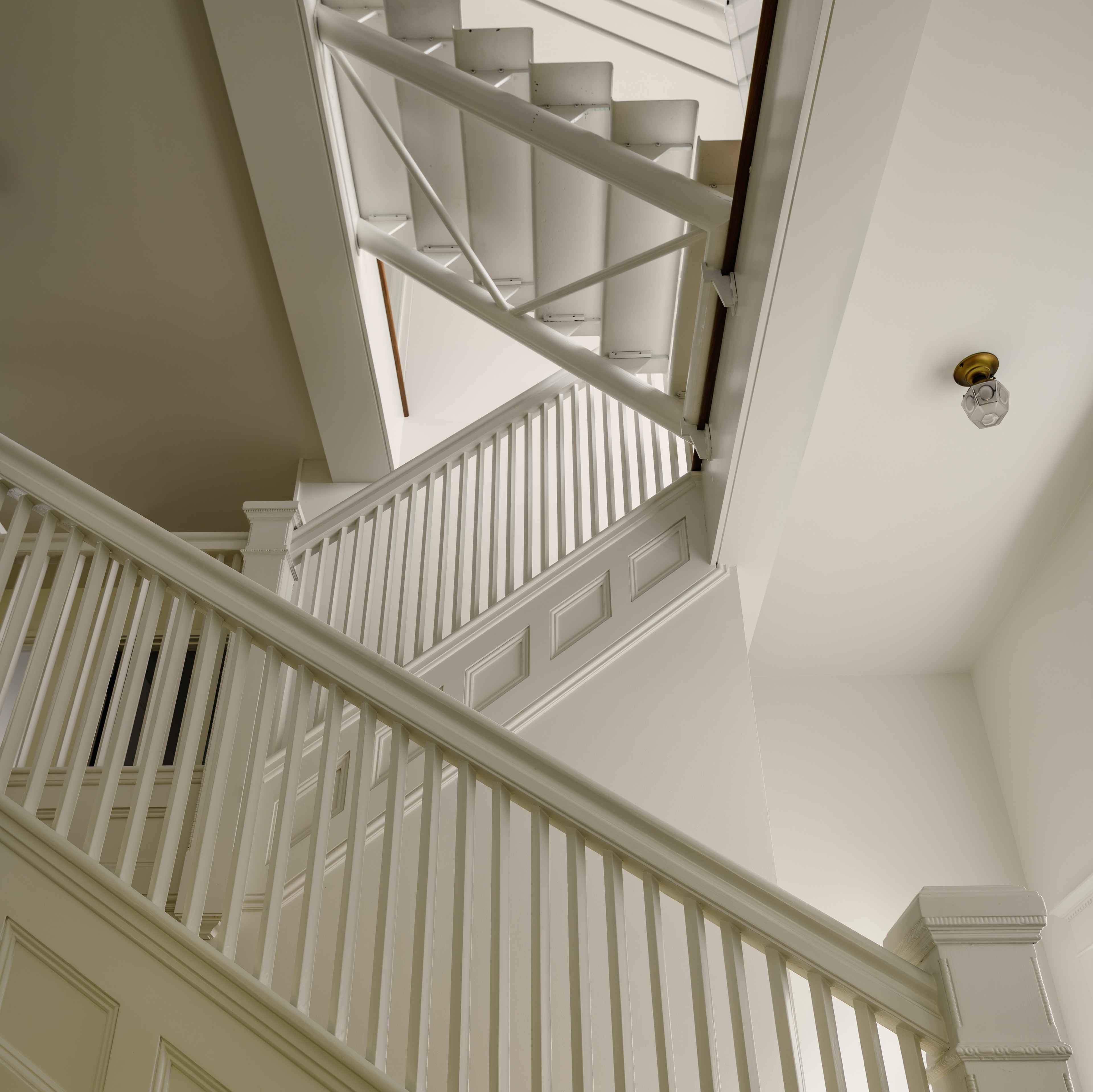 a white stair case in a house with a light on