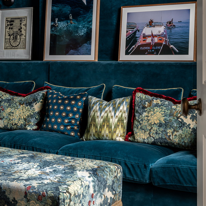 a living room with a blue couch and pictures on the wall