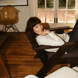 a woman sitting in a chair in front of a window