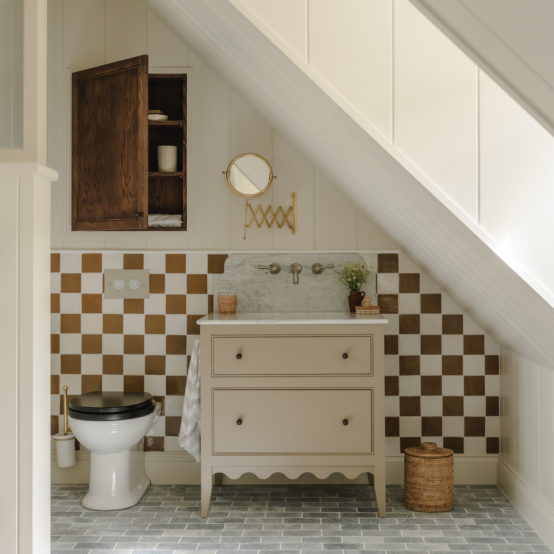 a bathroom with a toilet and a sink under a slanted ceiling