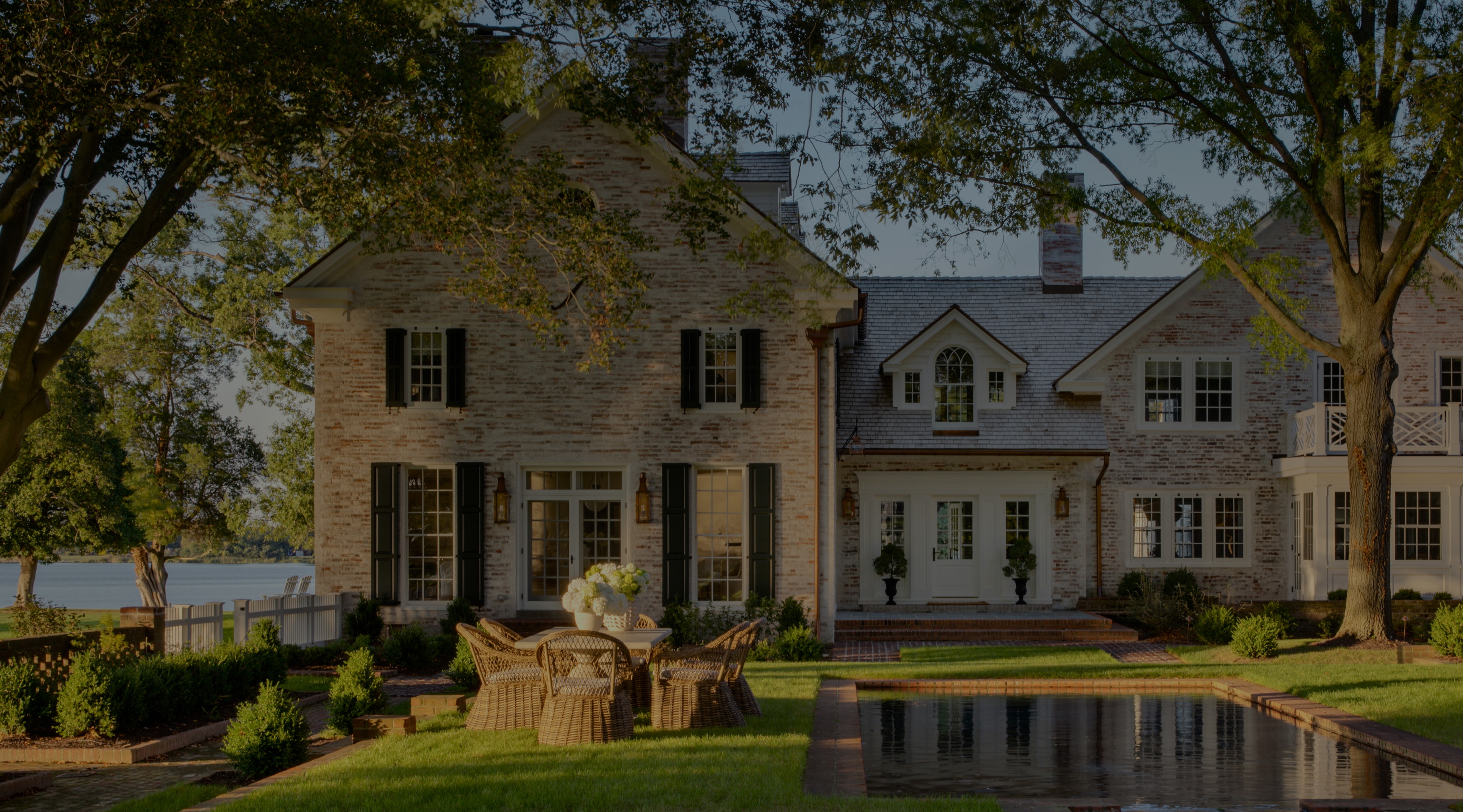 a large house with a pond in front of it