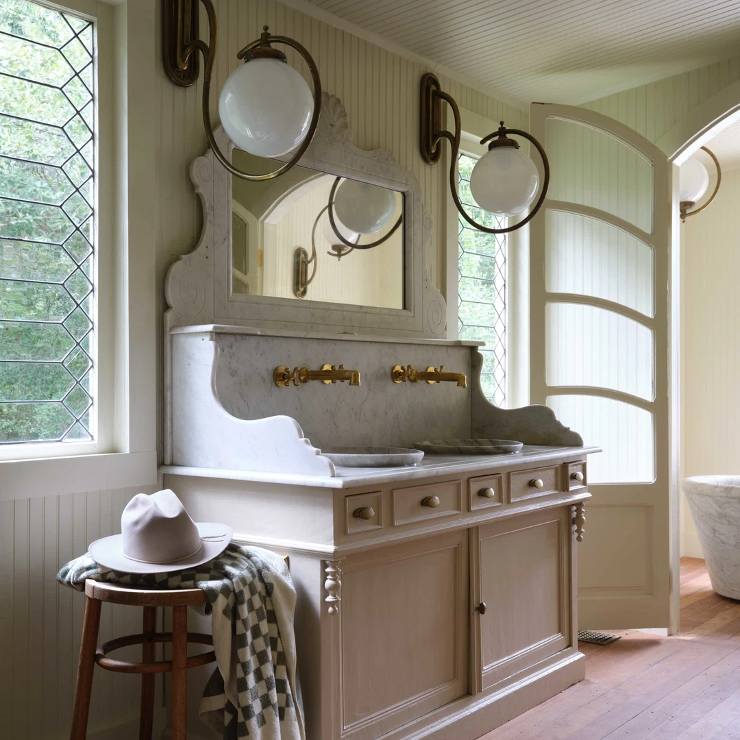 a bathroom with a sink, mirror and stool