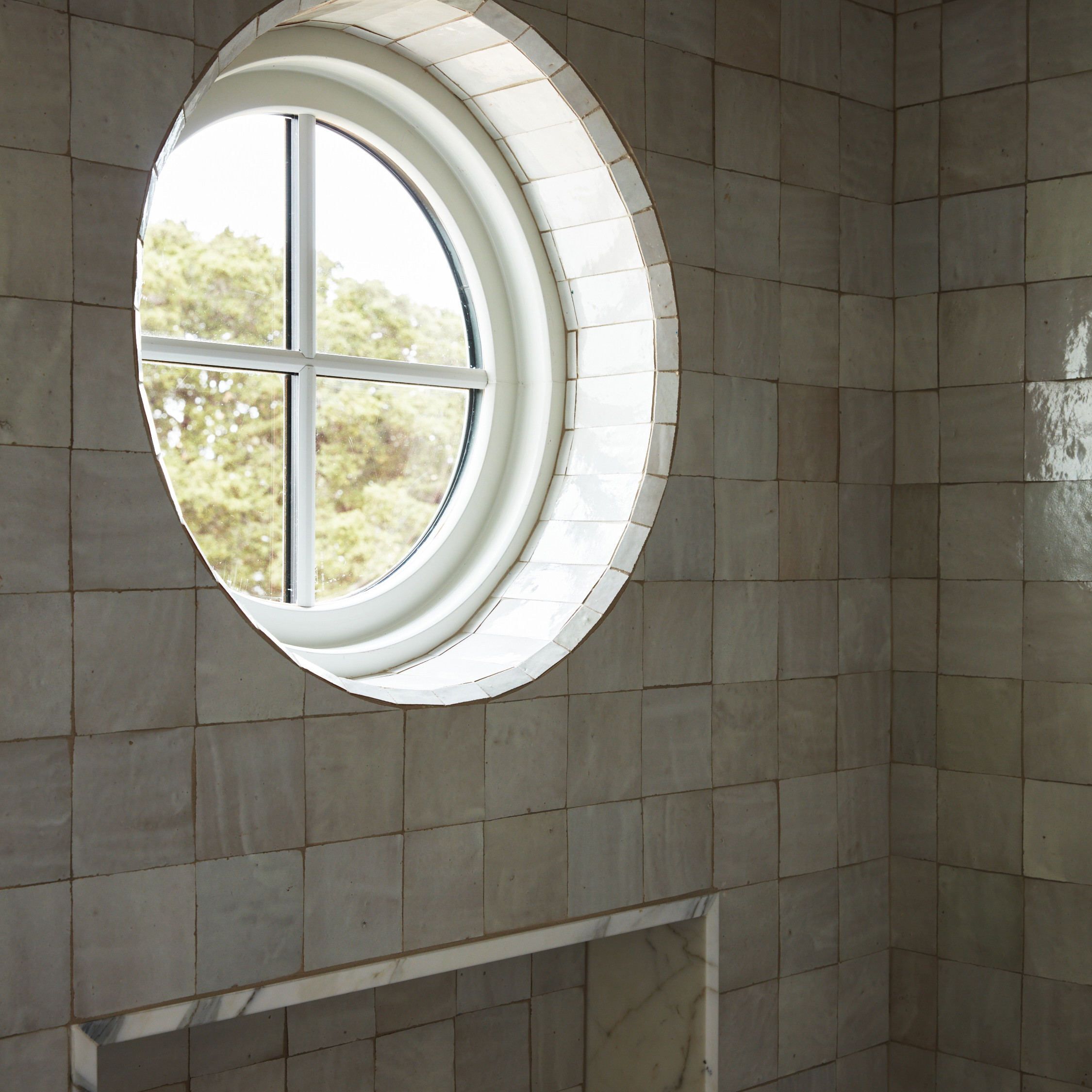 a bathroom with a round window in the wall