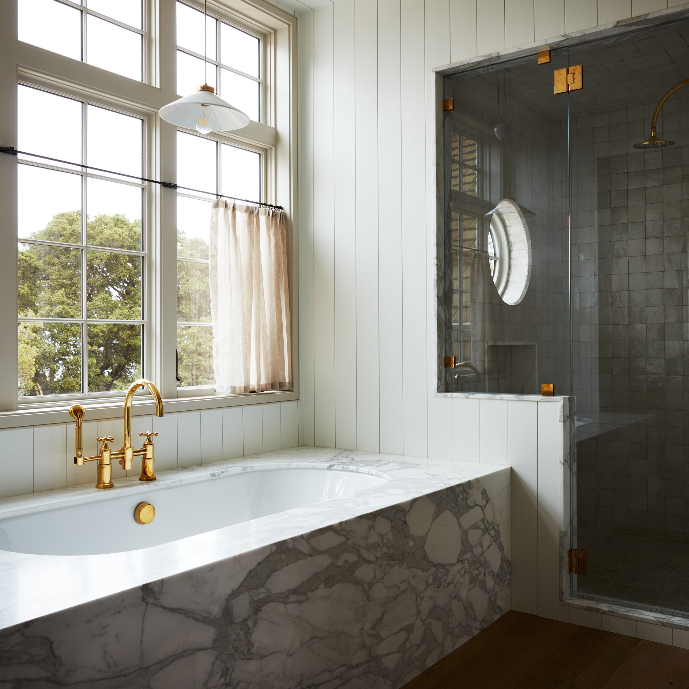 a bathroom with a marble bathtub next to a window