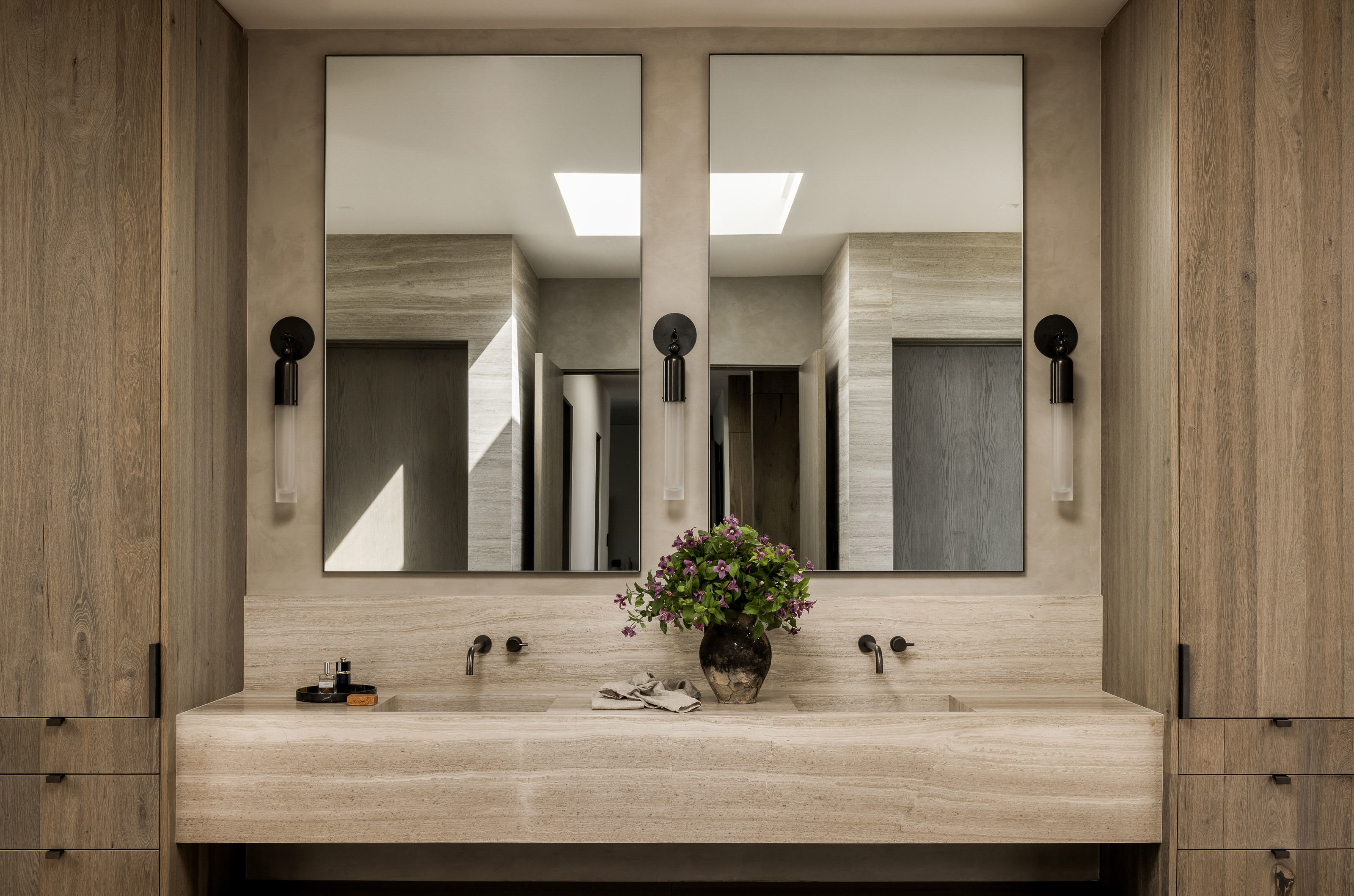 a bathroom sink with a vase of flowers on it