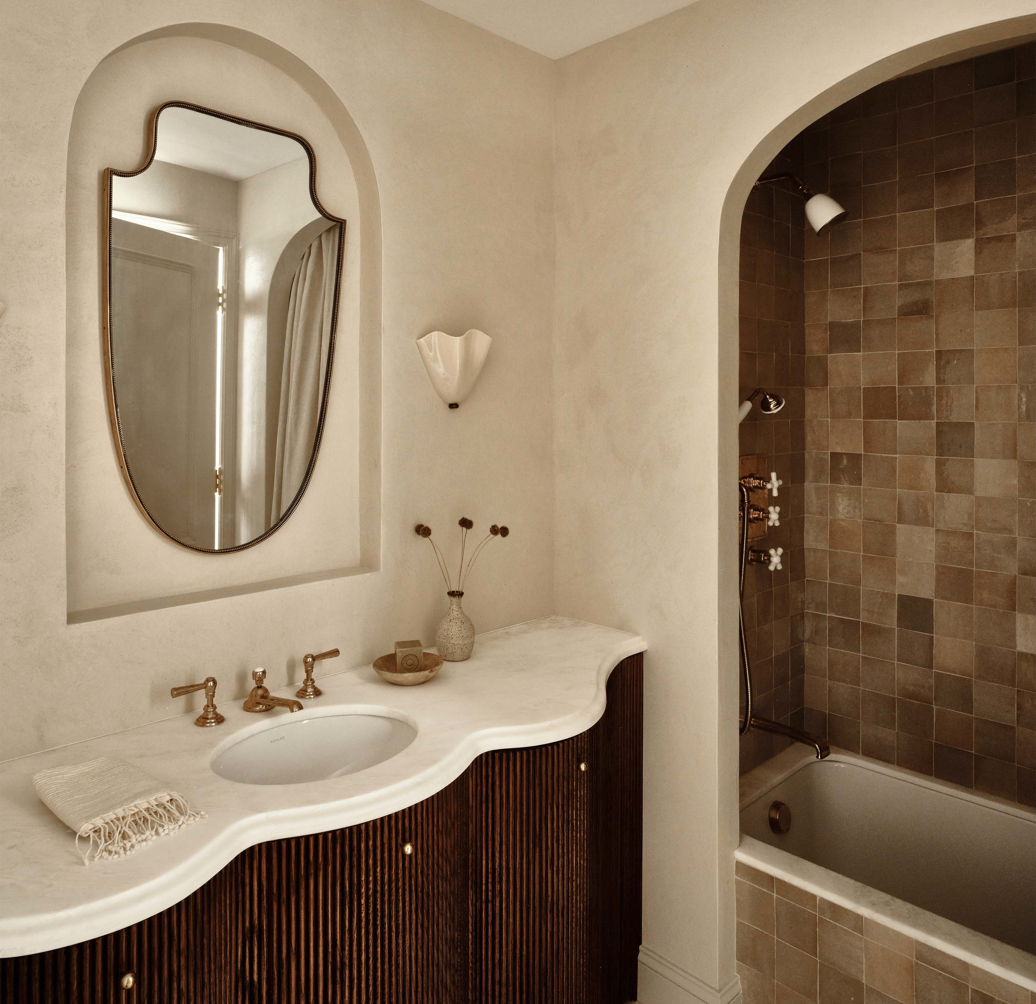 a bath room with a sink a mirror and a bath tub