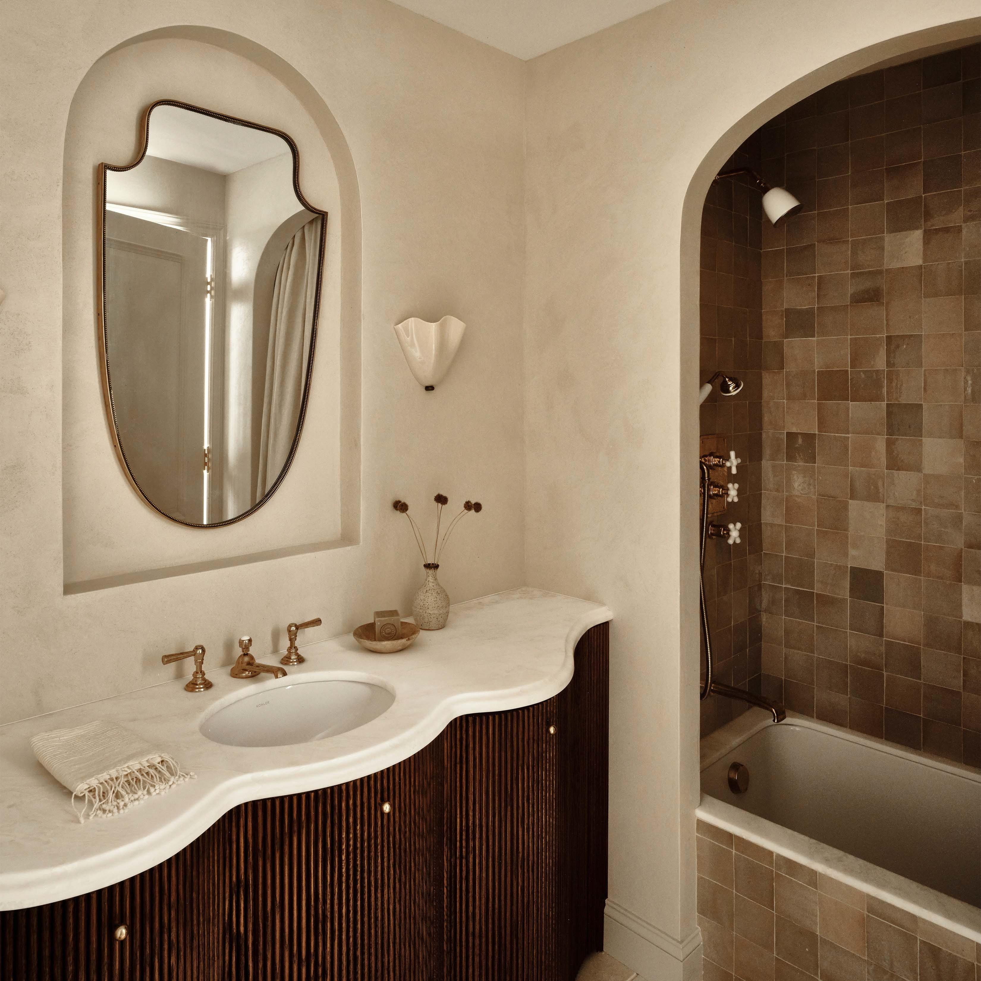 a bath room with a sink a mirror and a bath tub