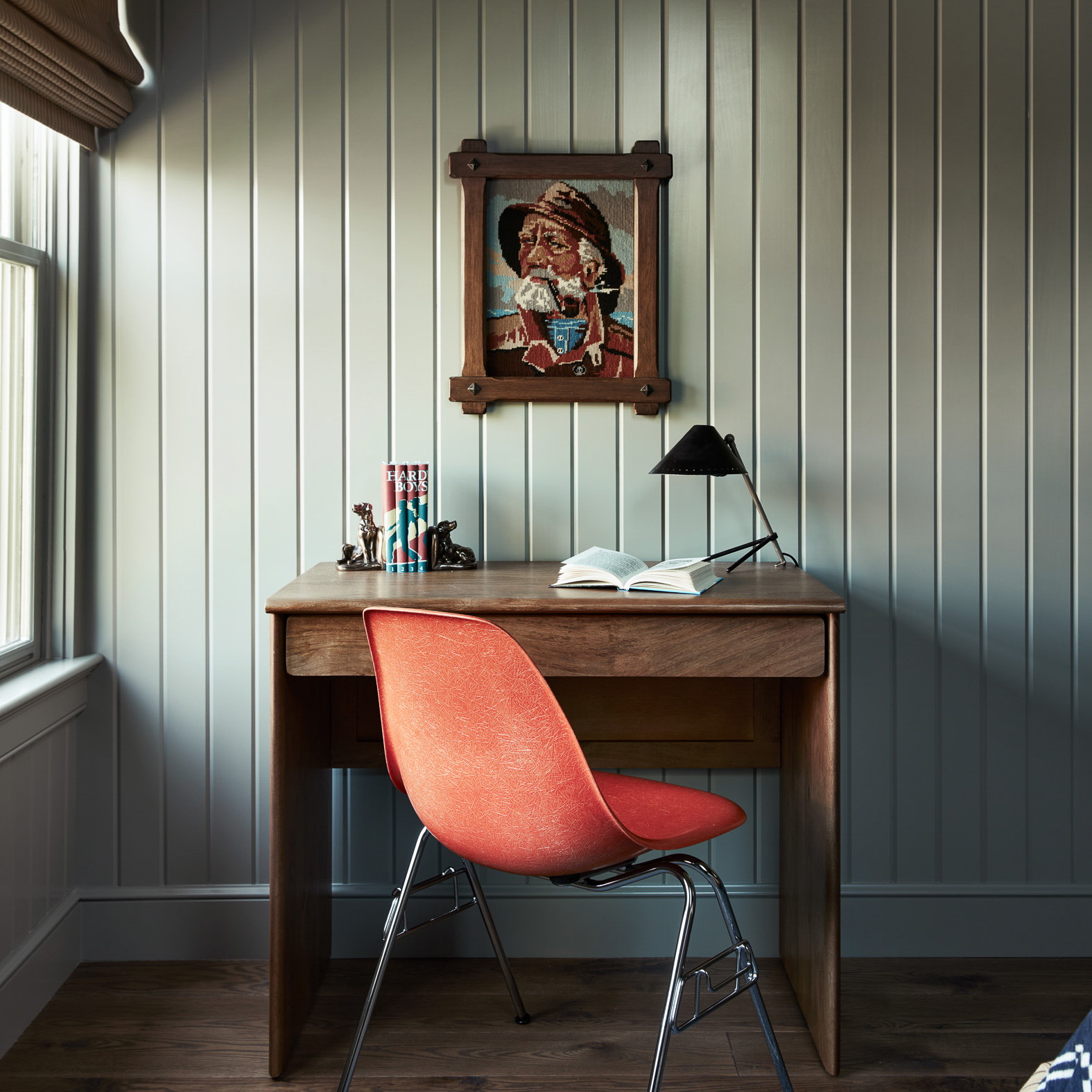 a desk with a chair and a painting on the wall