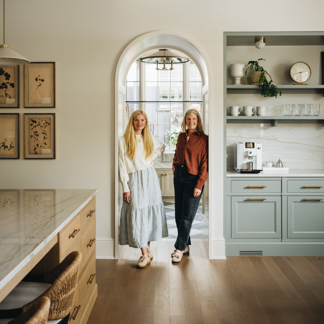 a couple of women standing in a kitchen next to each other