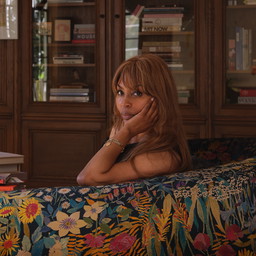 a woman sitting on a couch in a library