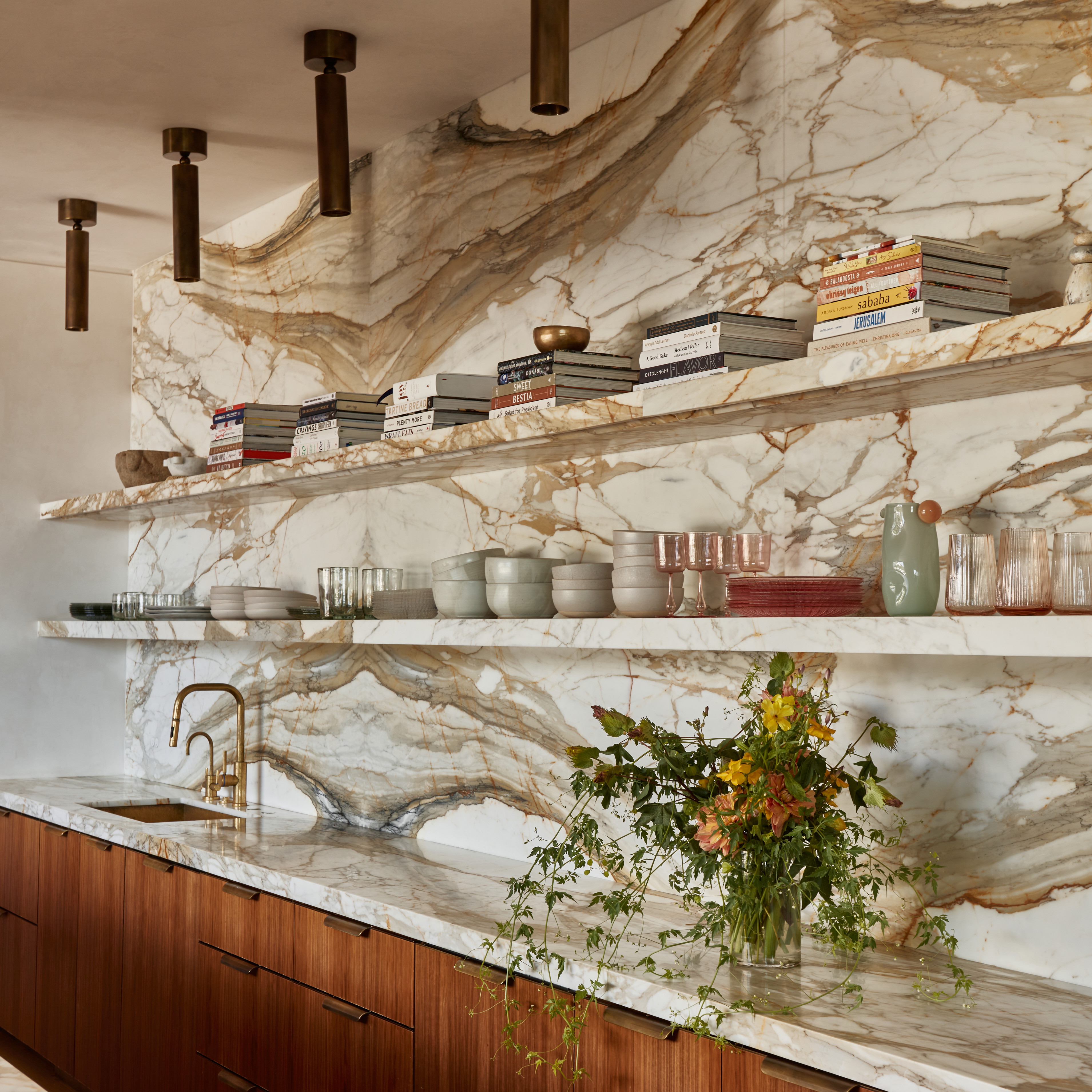 a kitchen with marble counter tops and wooden cabinets