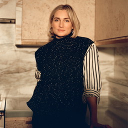 a woman standing in a kitchen next to a counter