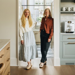 a couple of women standing in a kitchen next to each other