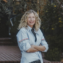 a woman standing on a brick walkway with her arms crossed