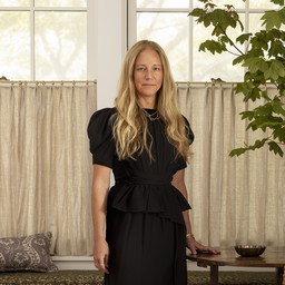 a woman standing in front of a window in a living room