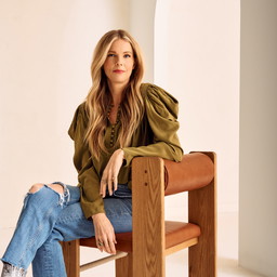 a woman is sitting on a wooden bench