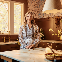 a woman standing in a kitchen next to a counter