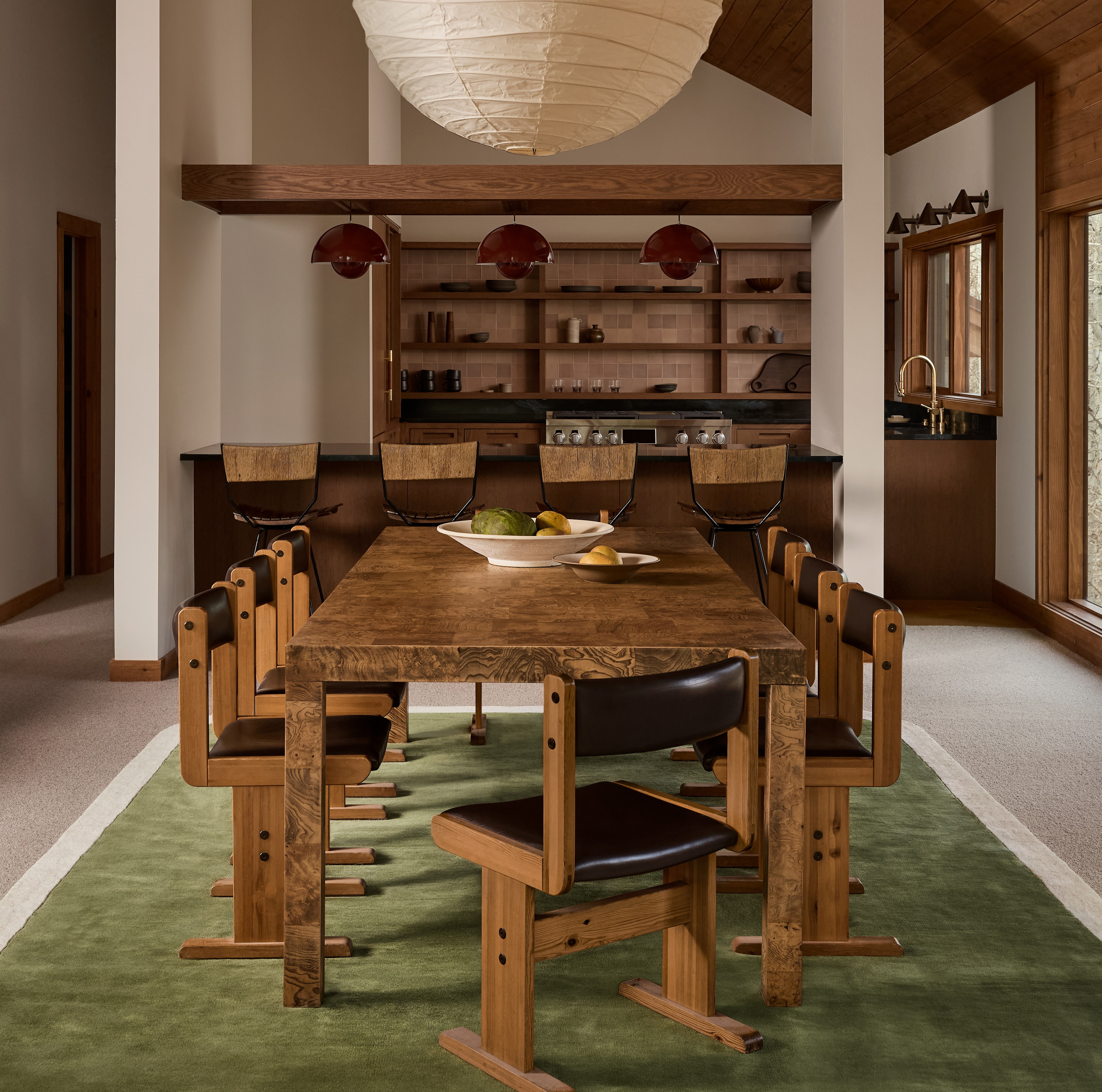 a dining room with a large wooden table surrounded by chairs