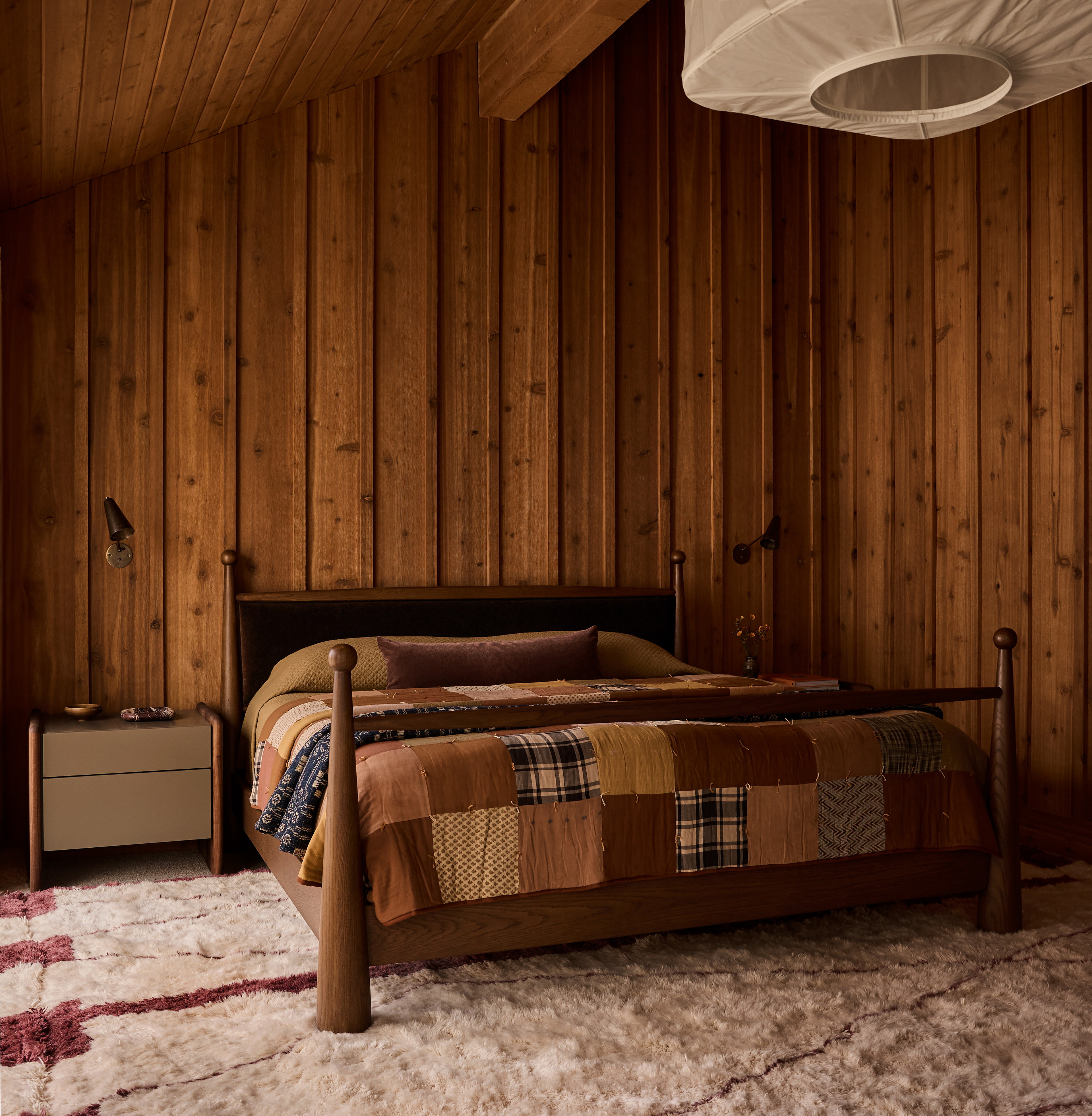 a bedroom with wood paneling and a bed