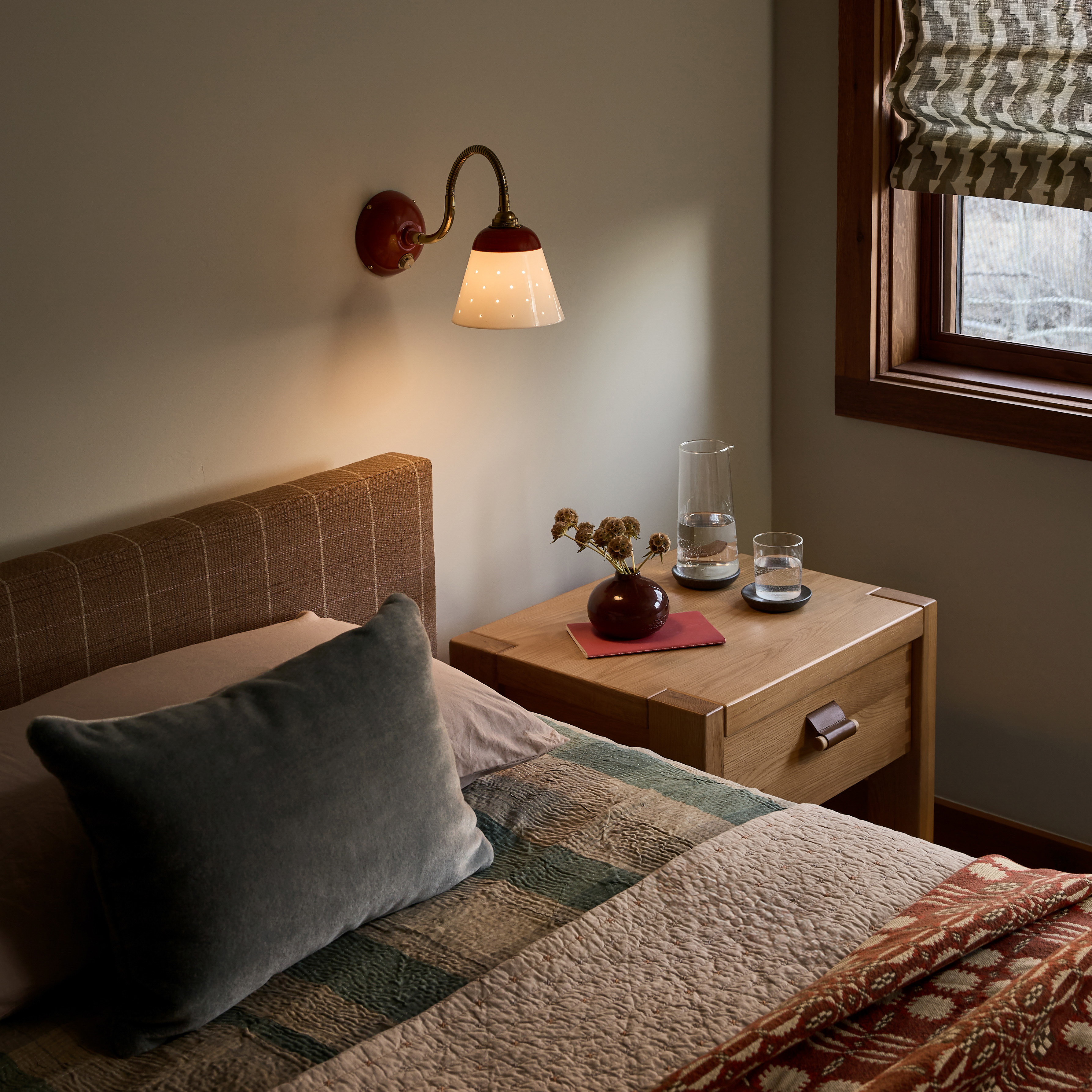 a bed room with a neatly made bed and a night stand