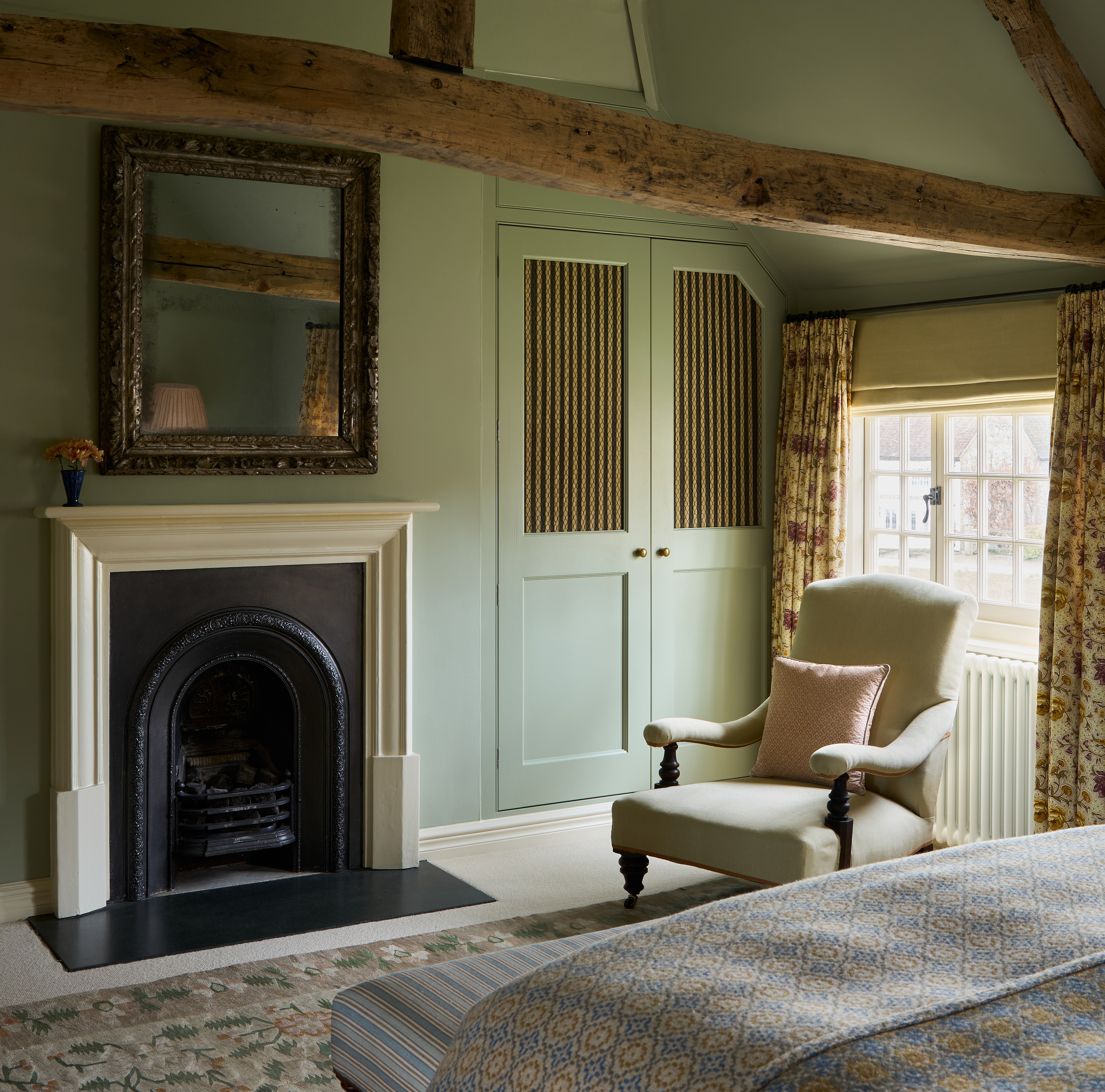 a bedroom with a fireplace and a chair