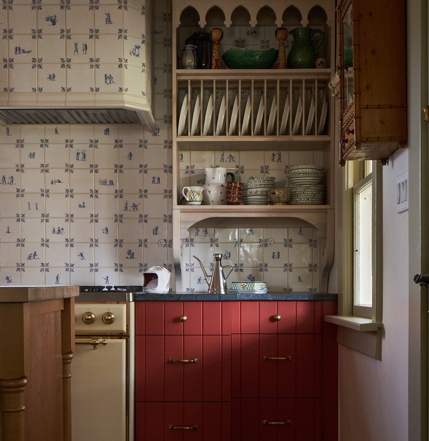 a kitchen with red cabinets and white walls