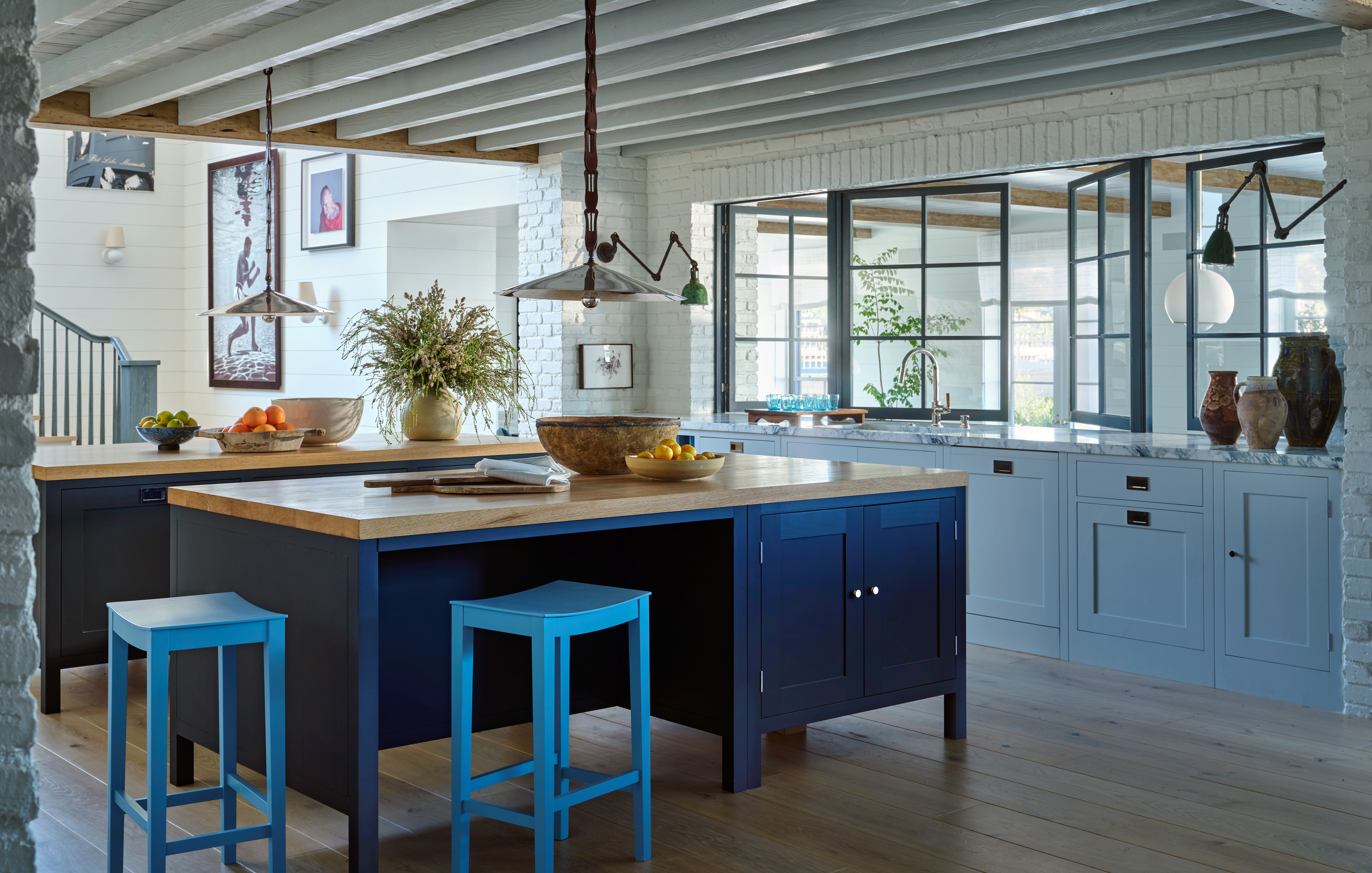 a kitchen with a center island and blue stools