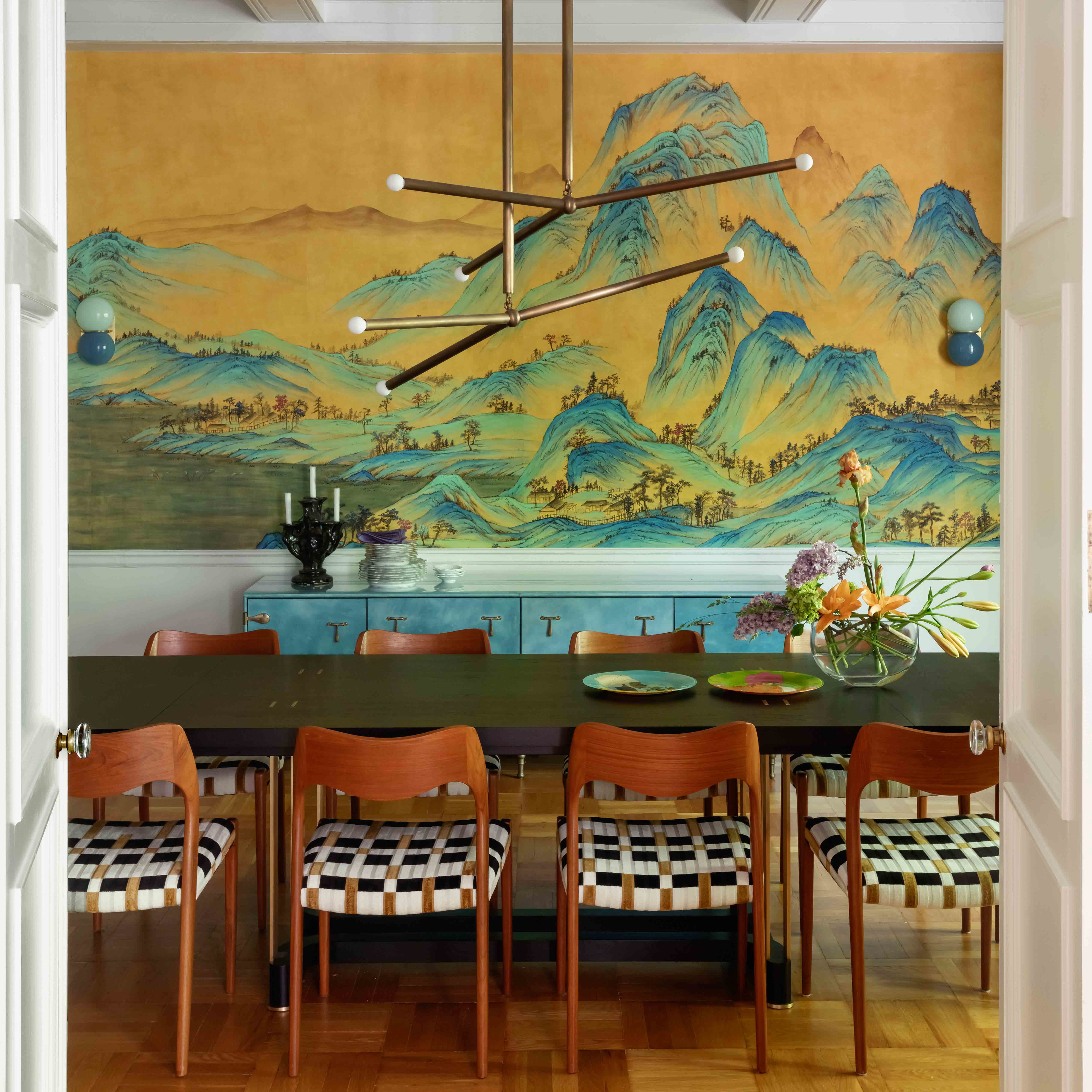 a dining room with a large painting on the wall