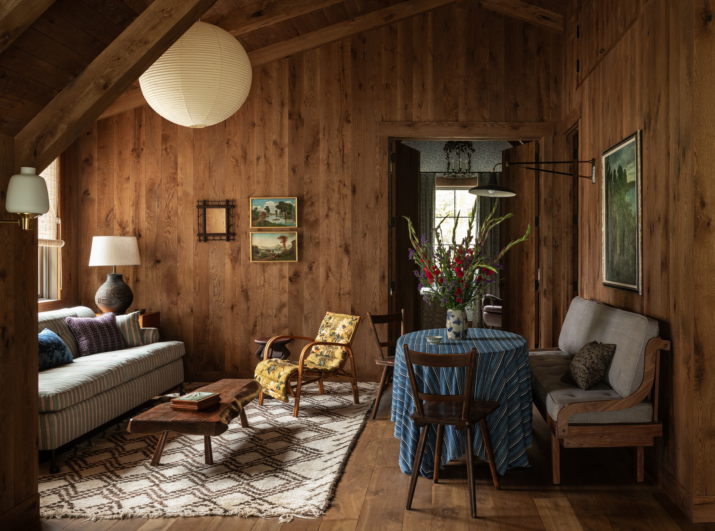 a living room filled with furniture and wooden walls