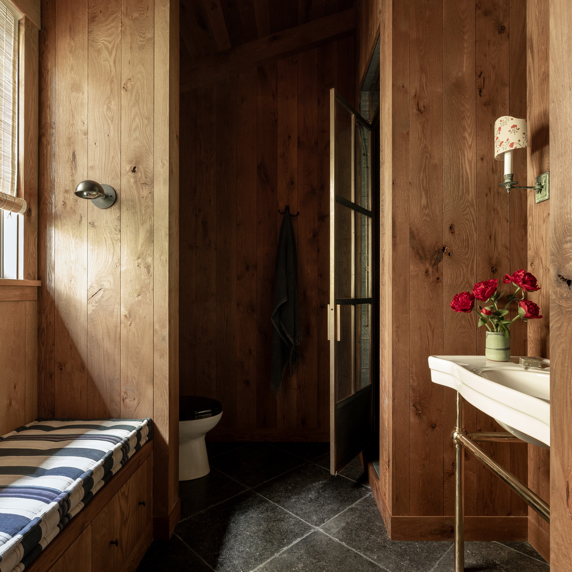 a bathroom with wooden walls and a window