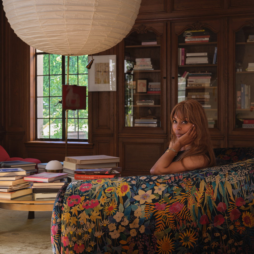 a woman sitting on a couch in a library