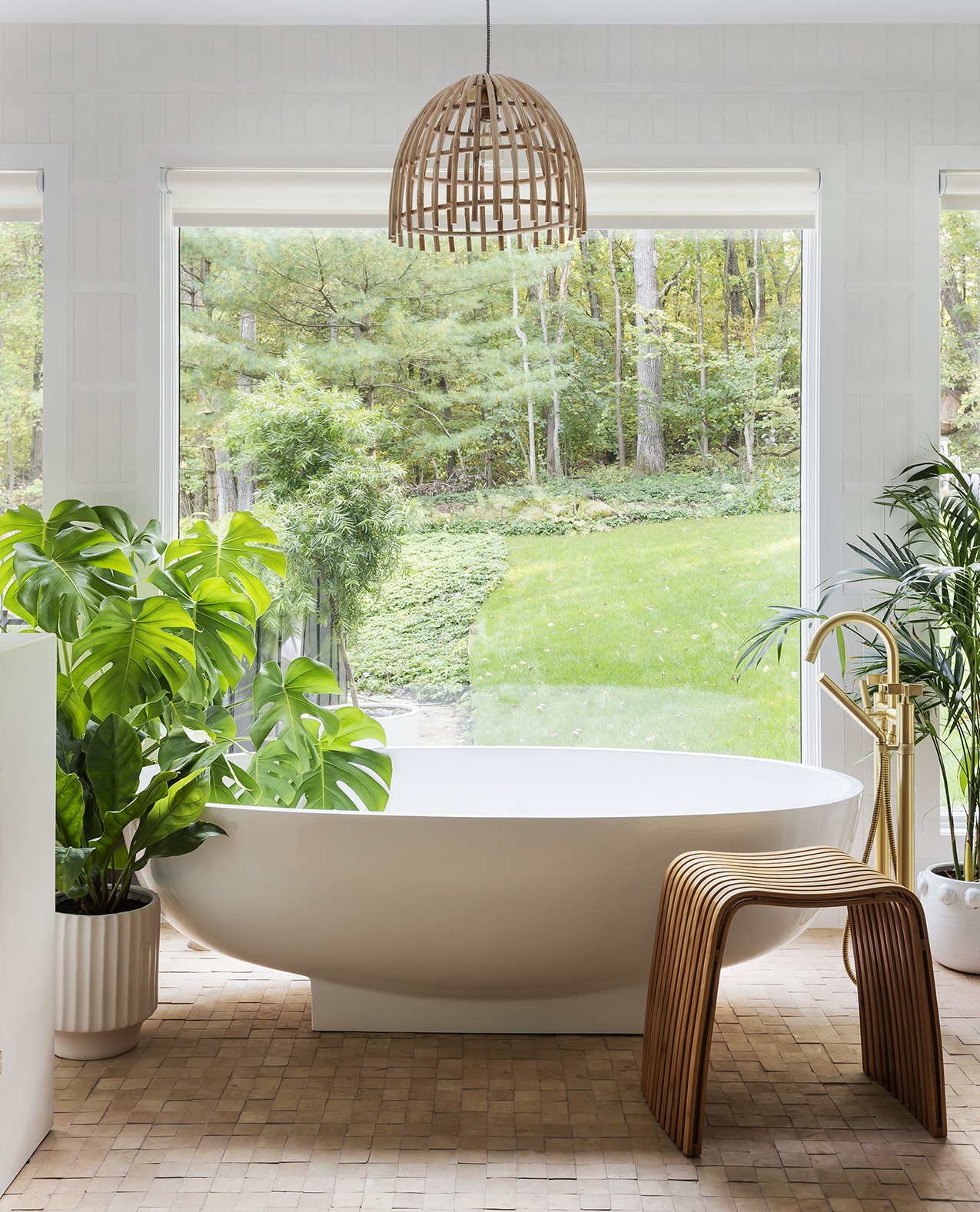 a bathroom with a large tub and potted plants