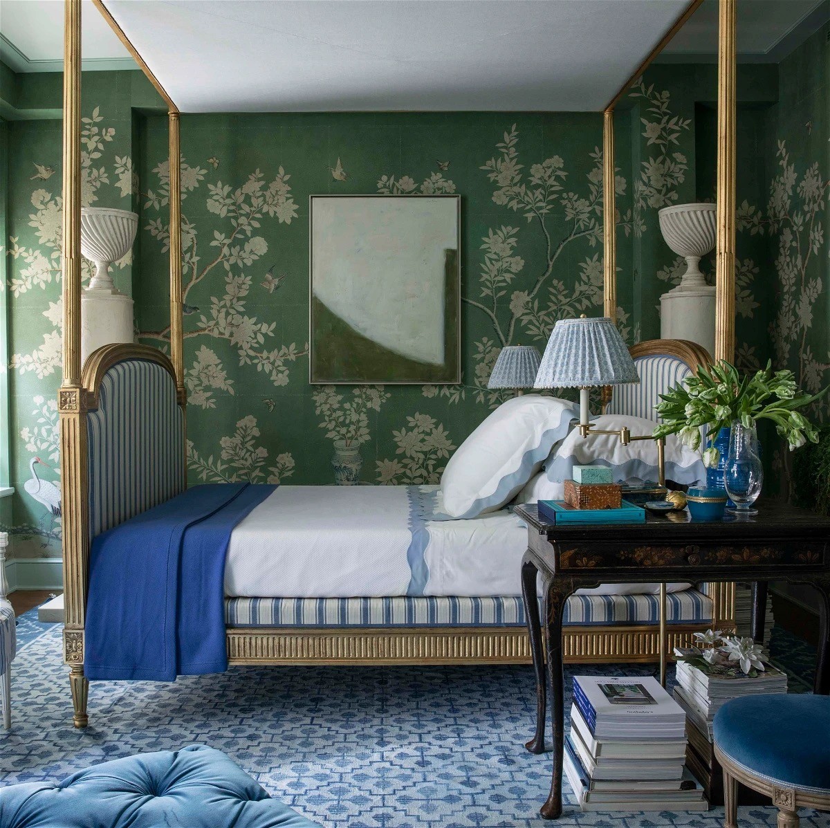 a bedroom with a canopy bed and a blue ottoman