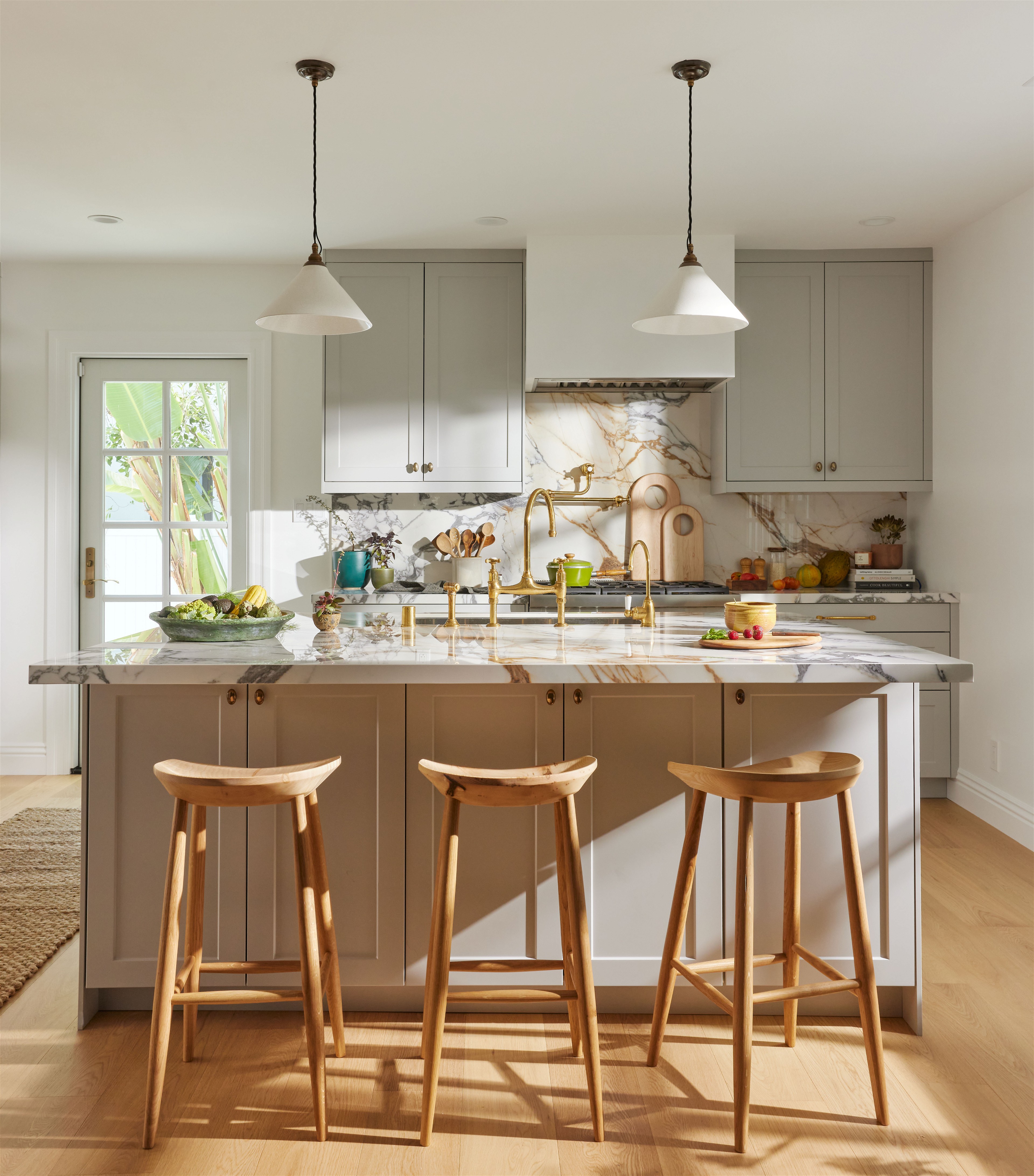a kitchen with three stools and a center island