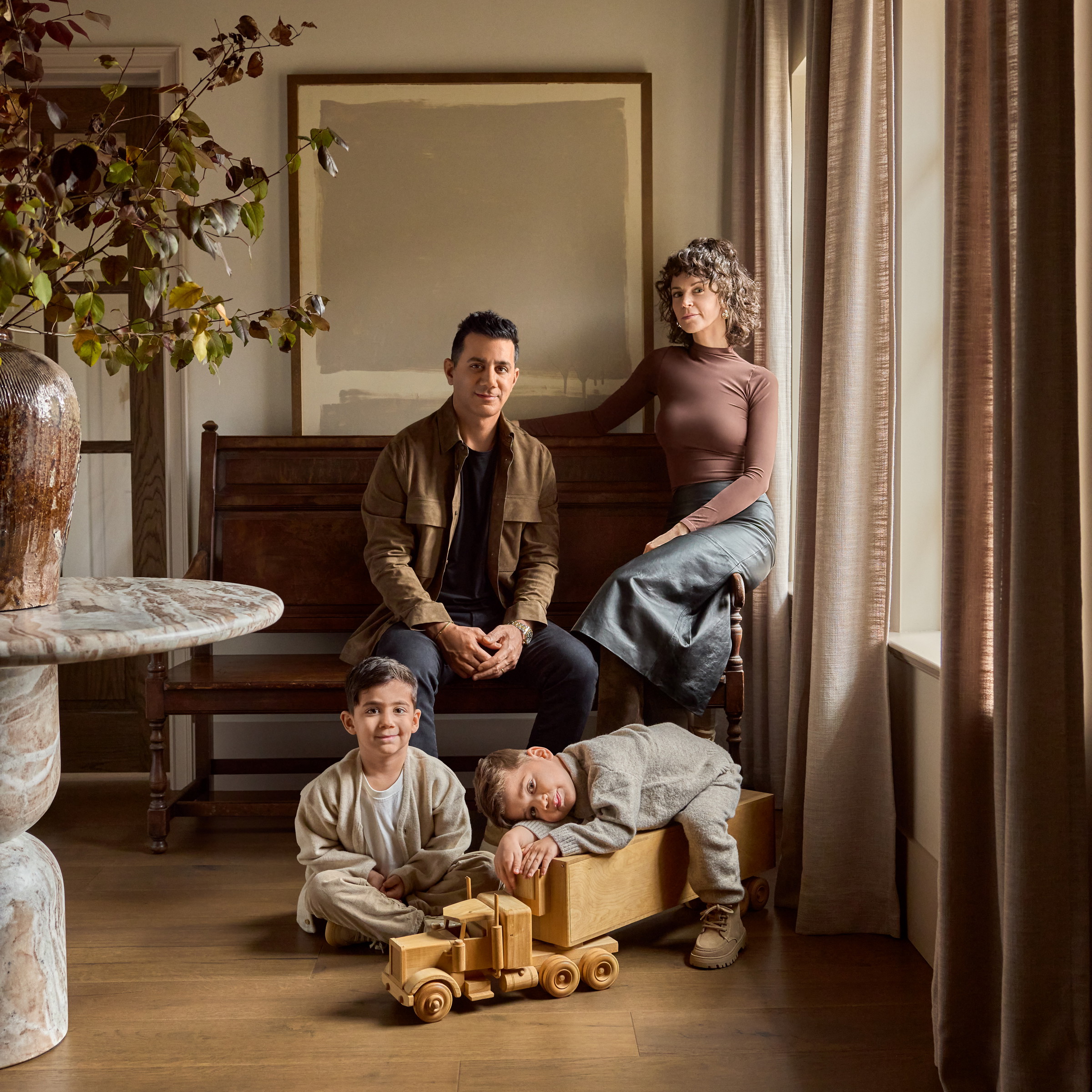 a family sitting on a bench in a living room