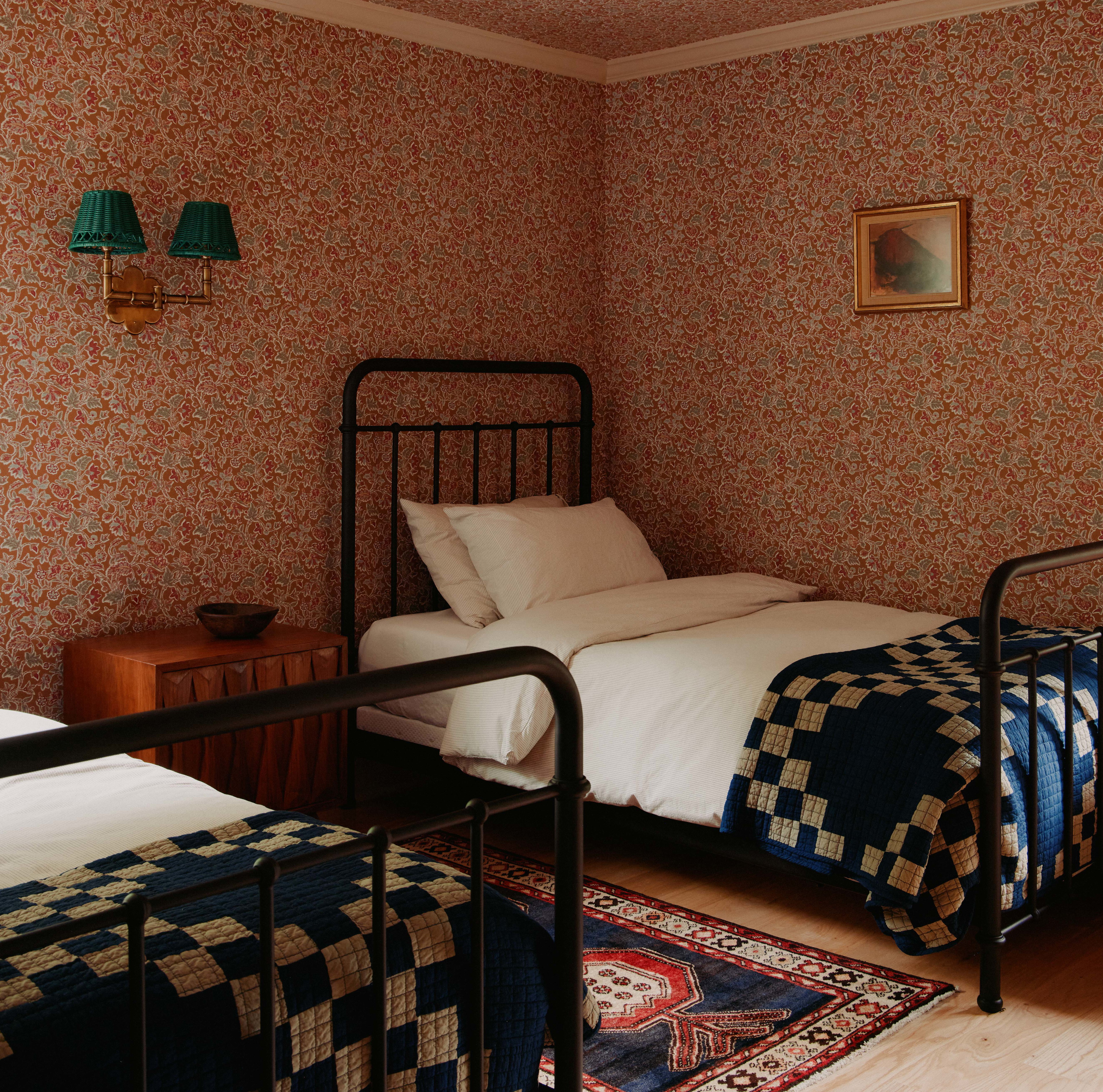 a bedroom with two beds and a rug on the floor