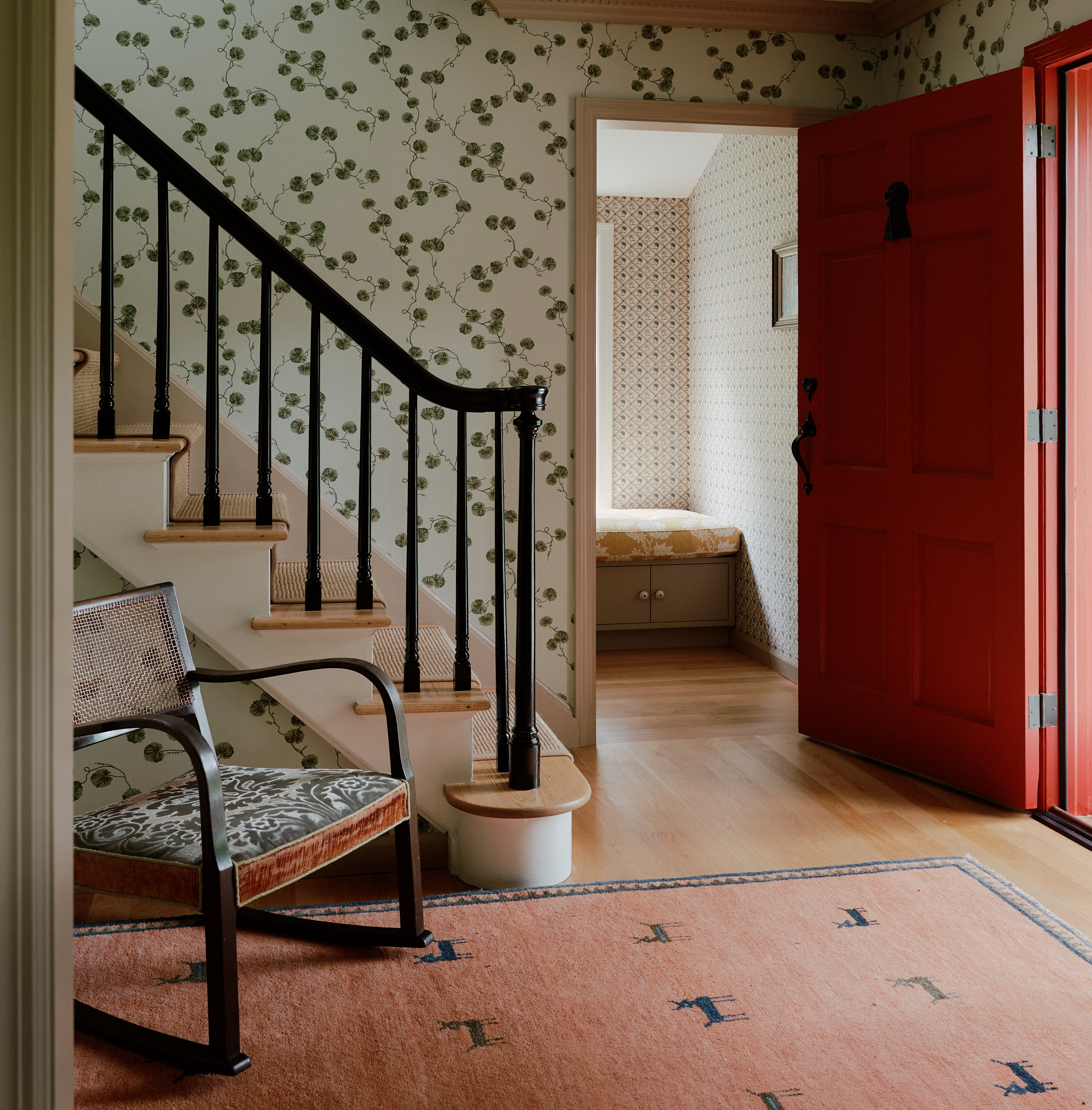 a room with a red door and a stair case