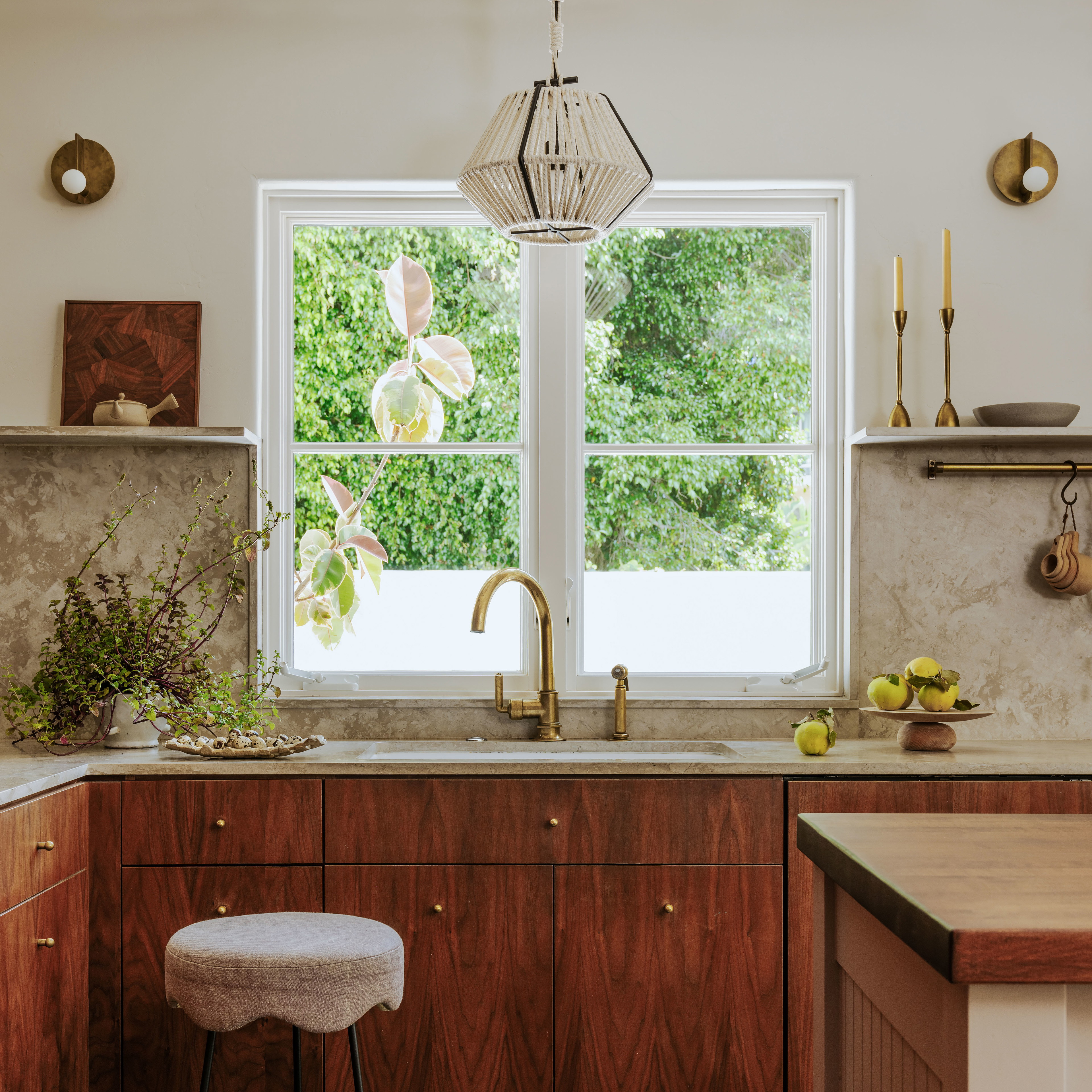 a kitchen with a window, sink, counter and stool