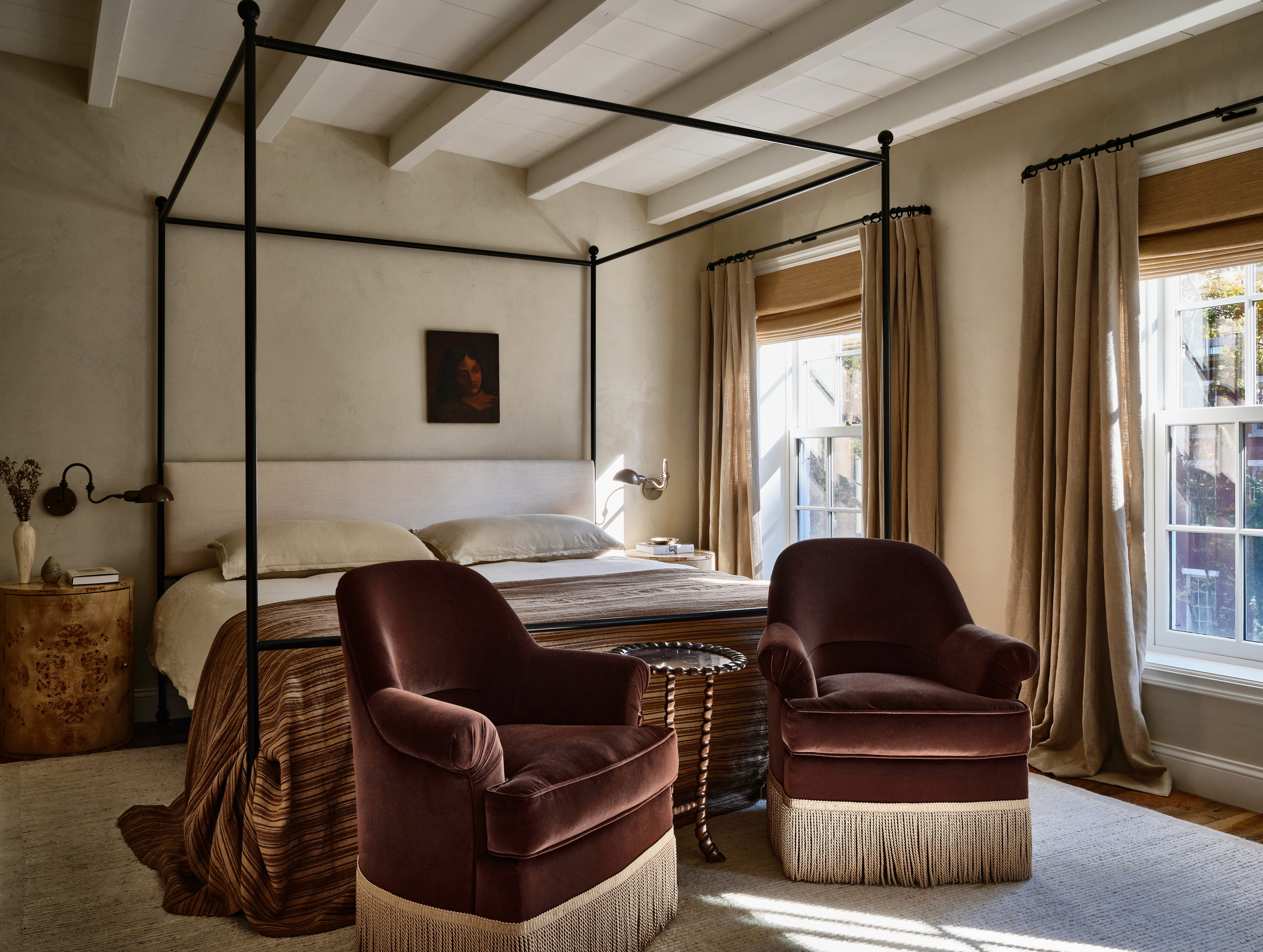 a bedroom with a canopy bed and two chairs