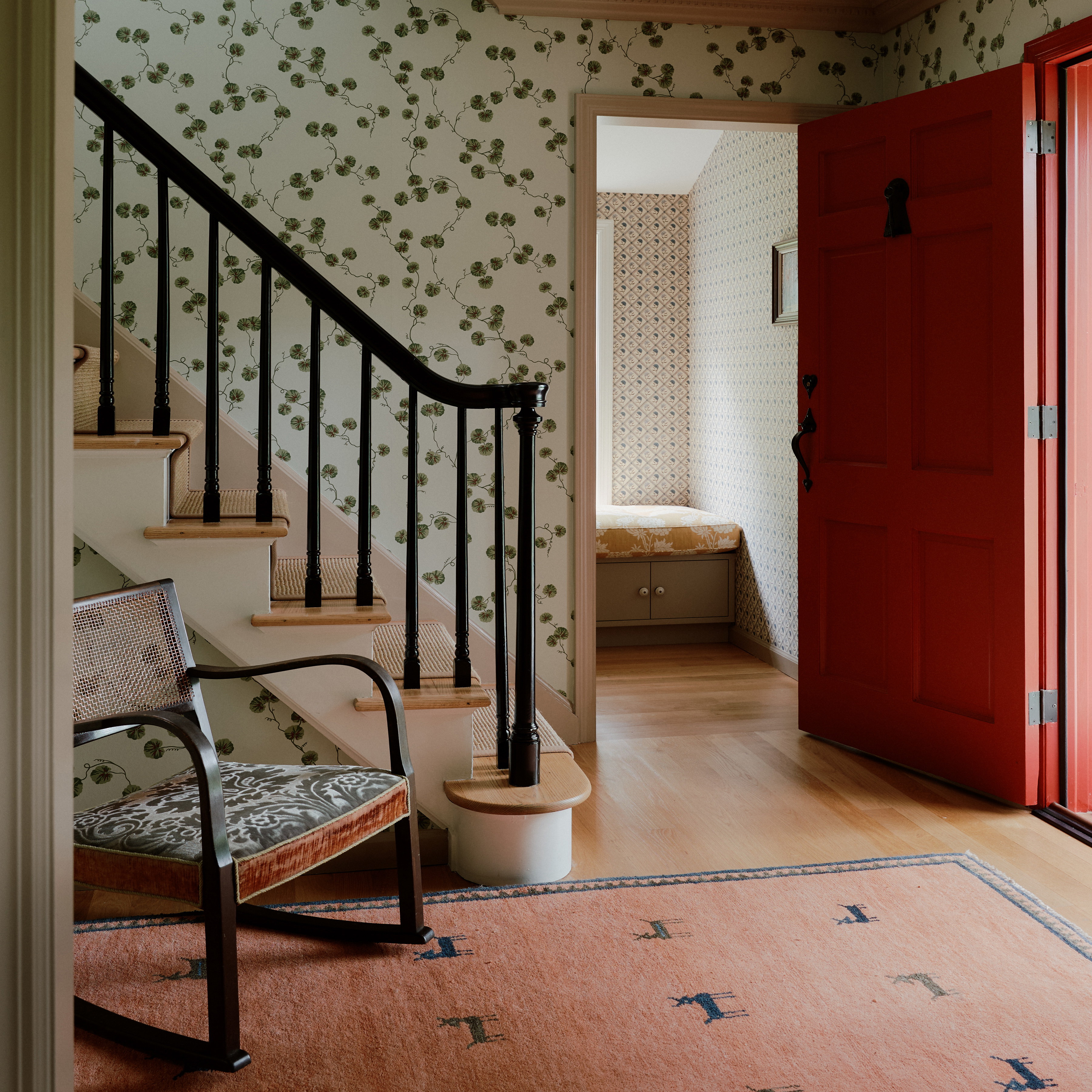 a room with a red door and a stair case