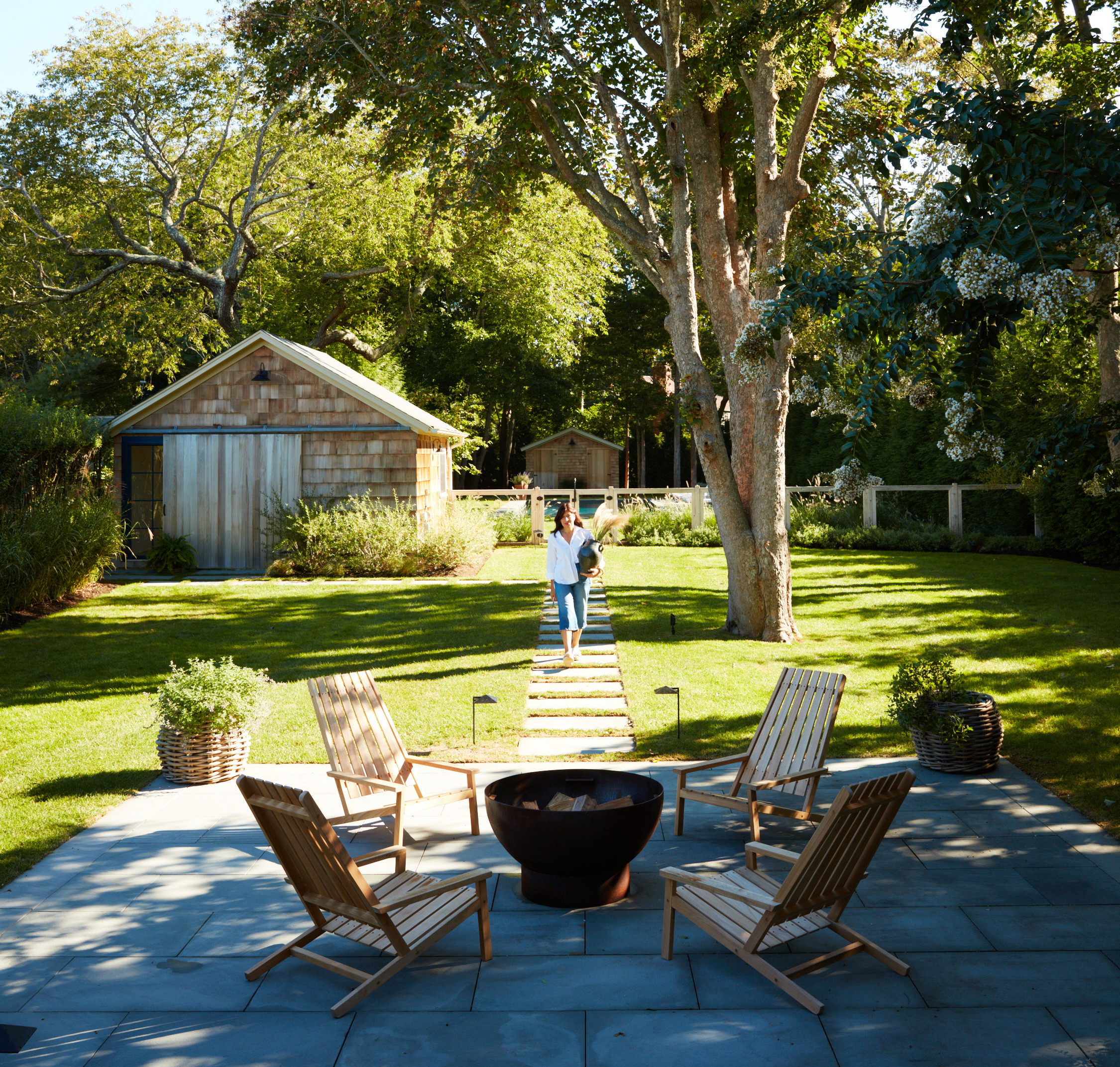 a man standing next to a tree in a yard