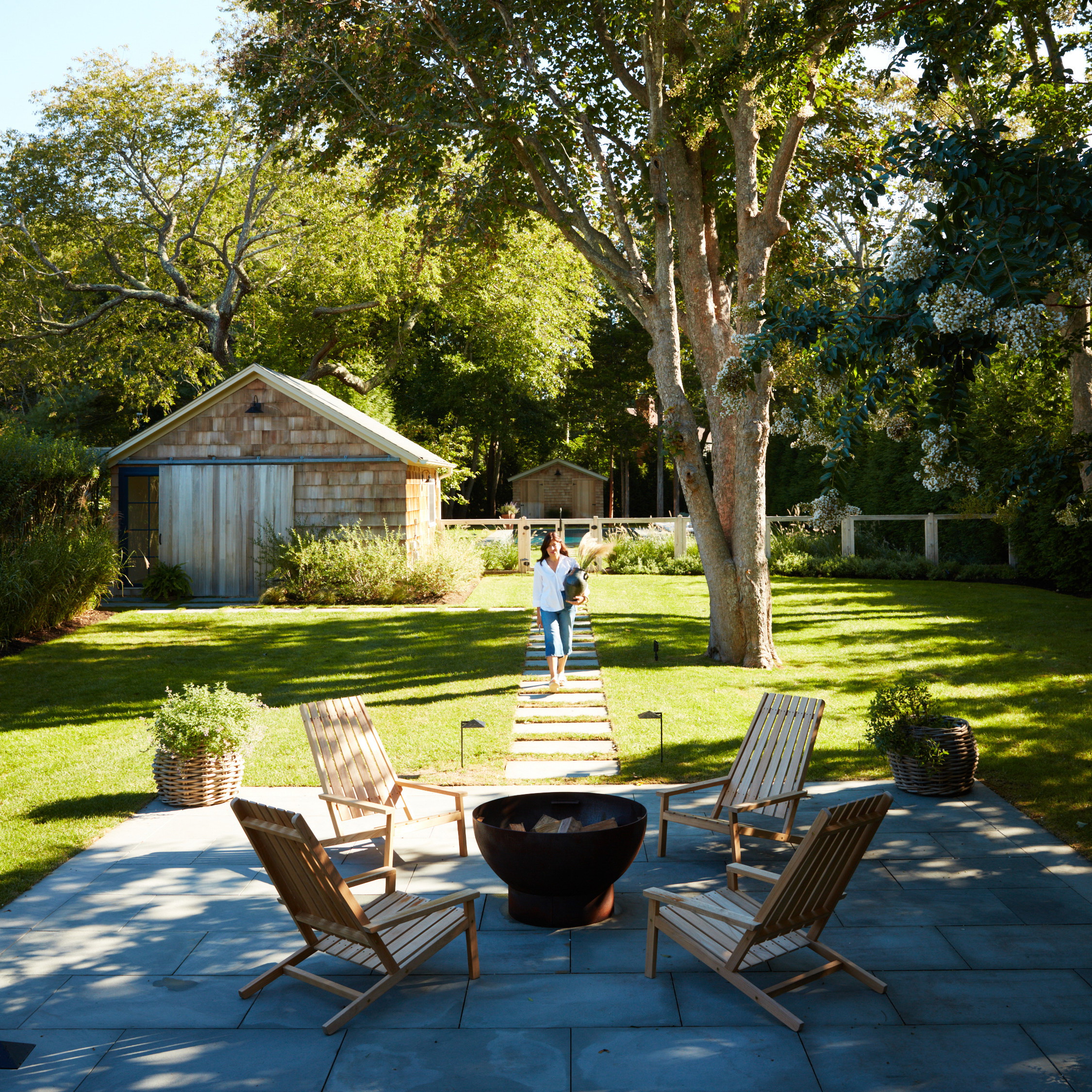 a man standing next to a tree in a yard